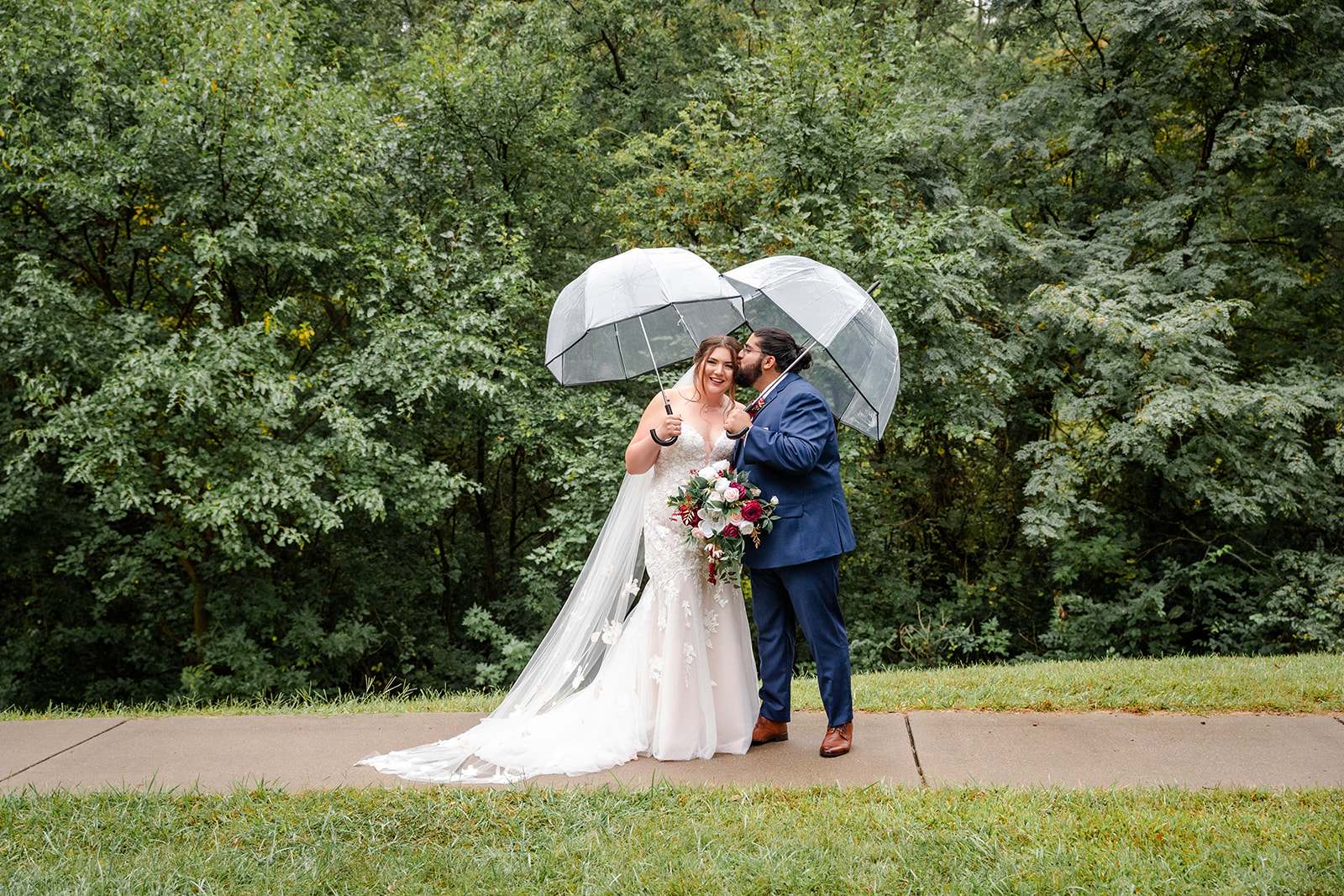 Bride and Groom kissing under a umbrella
