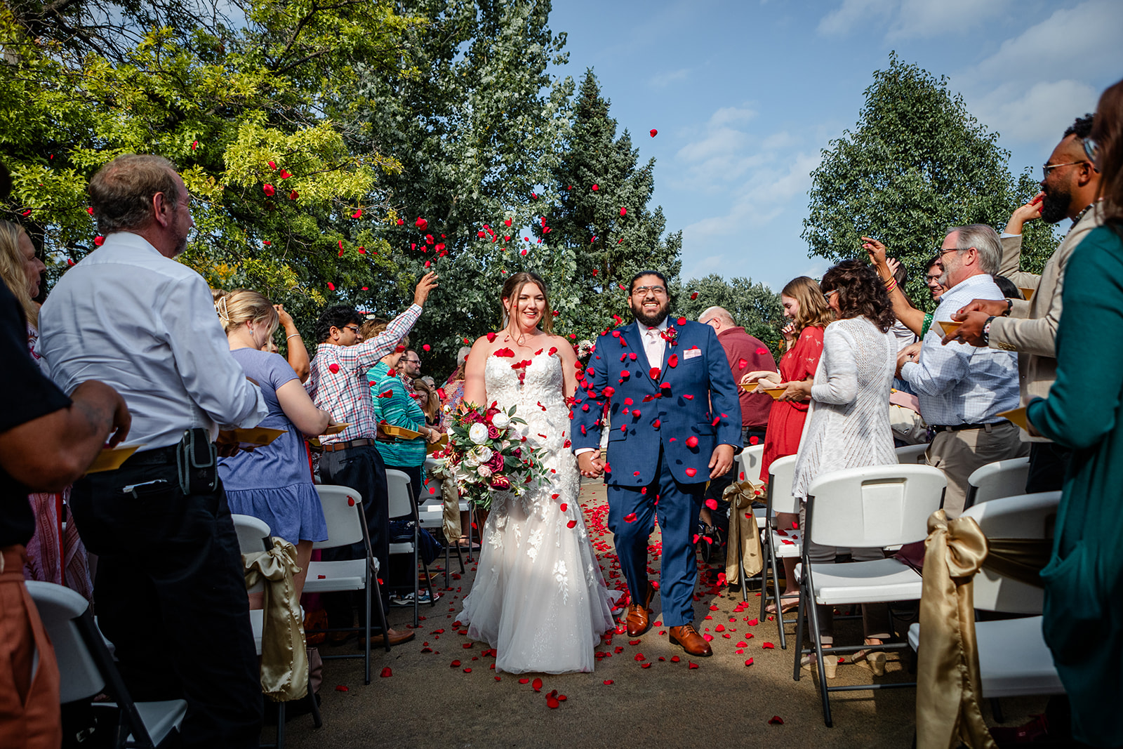 Bride and Groom walking through rose pedals