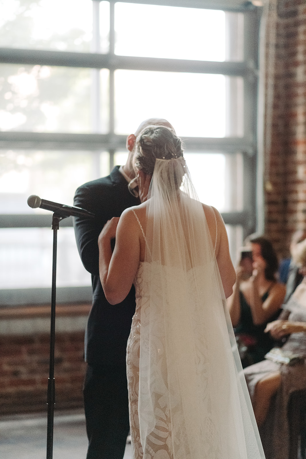 Bride and groom's first kiss was romantic and full of natural light from the large windows of Mile High Station.
