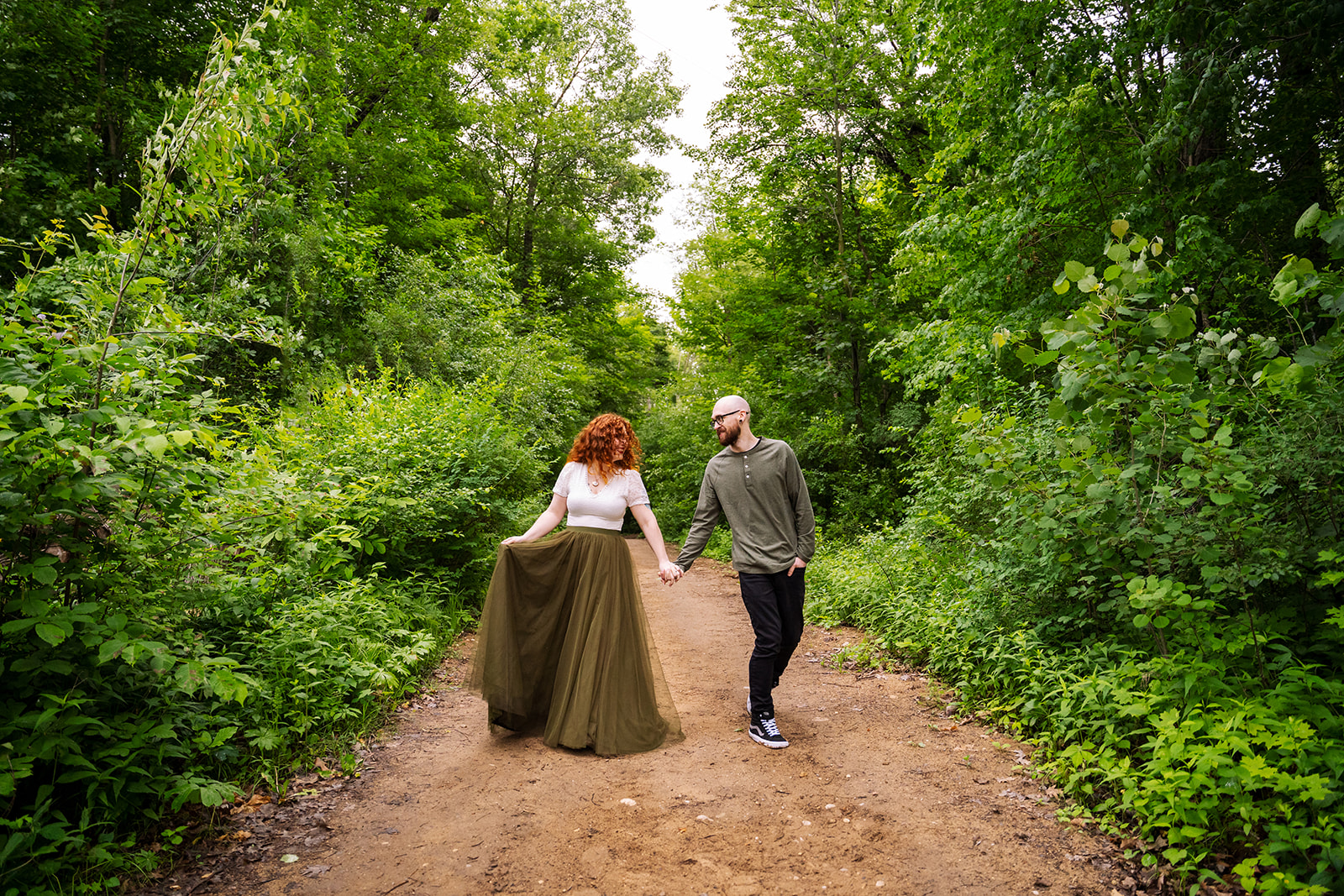 Engaged couple walks through the woods during their engagement session in Waukesha Wisconsin