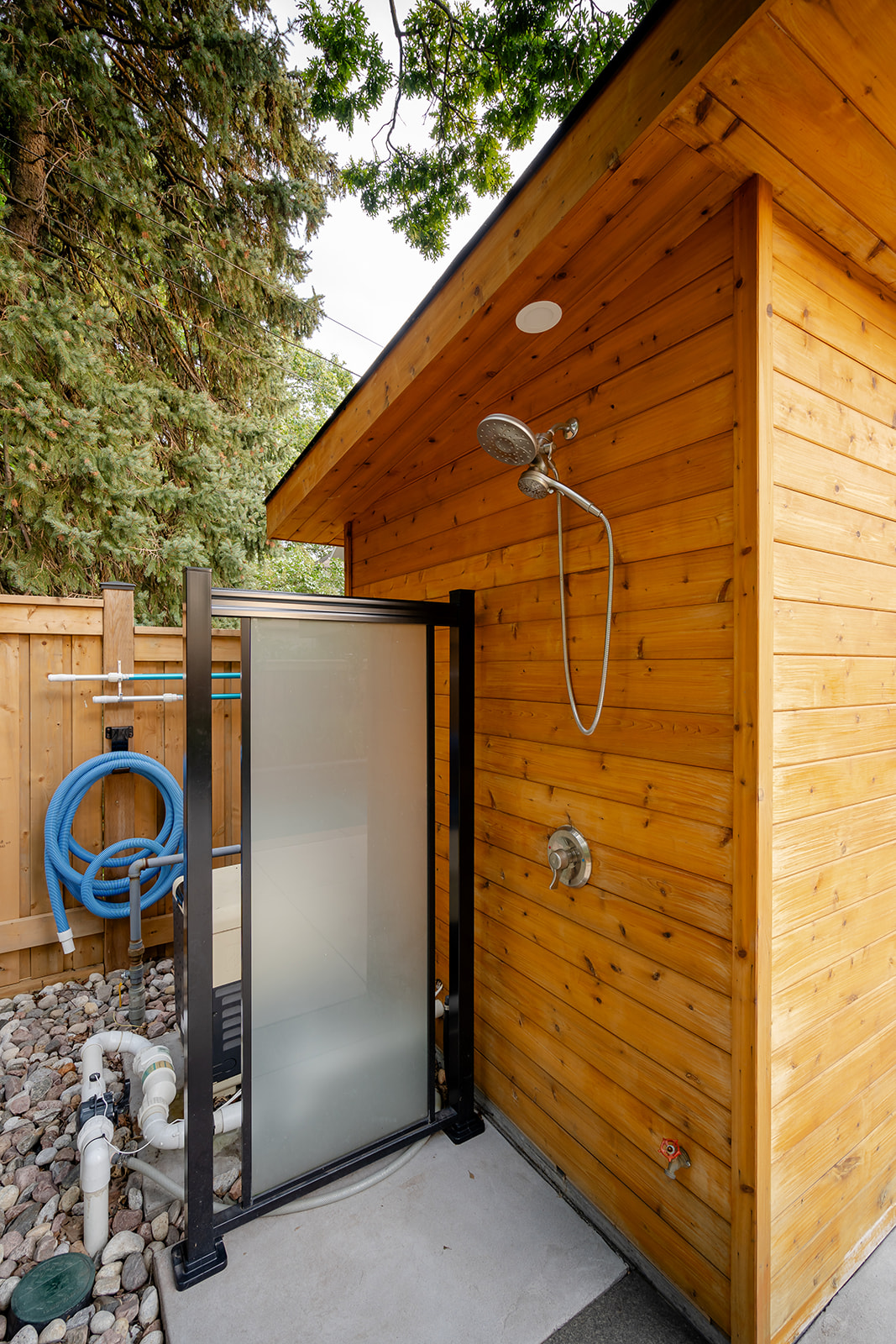 An outdoor shower on the side of the pool house.