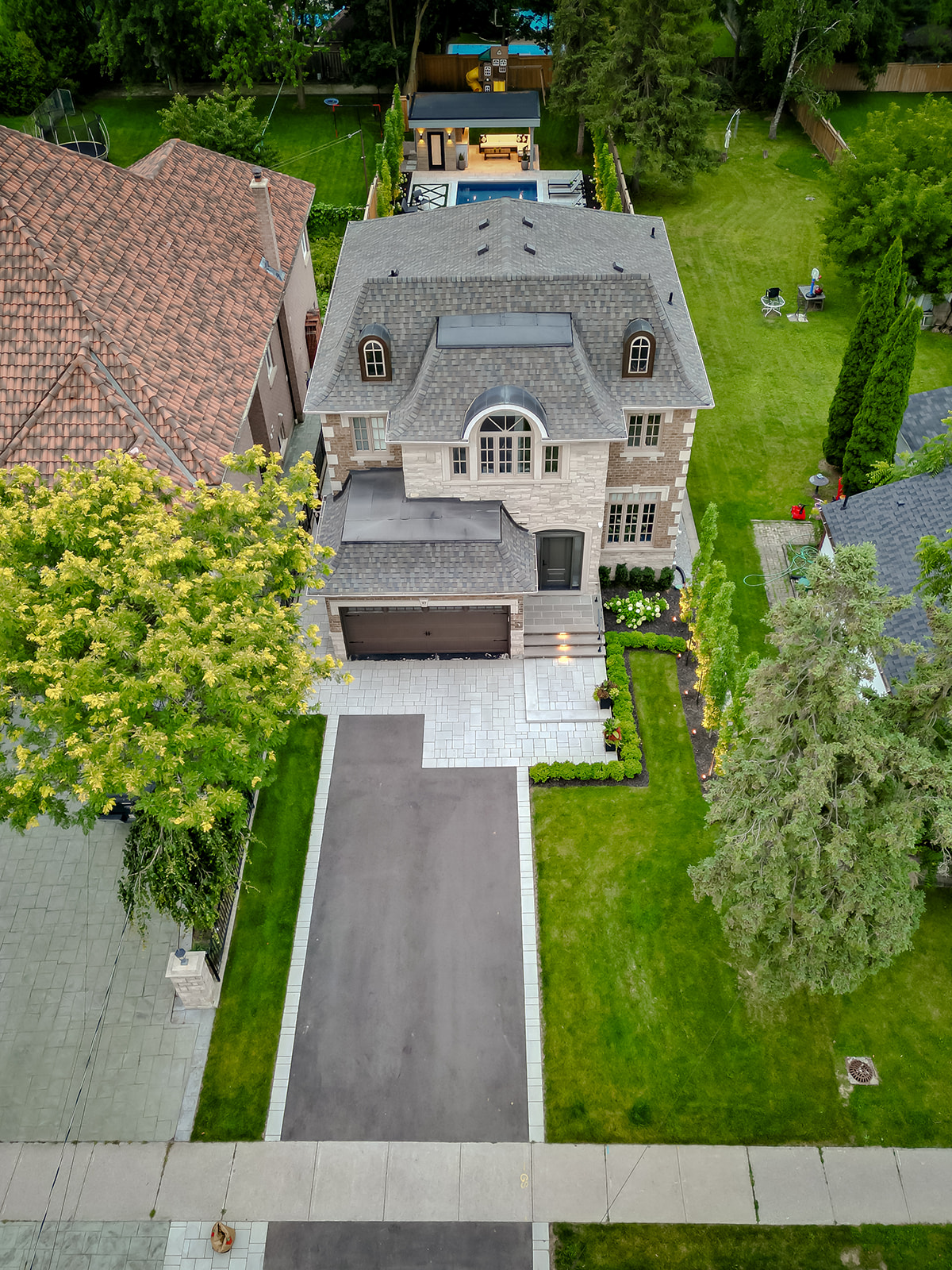 A drone shot of the front of the house with a paved driveway.