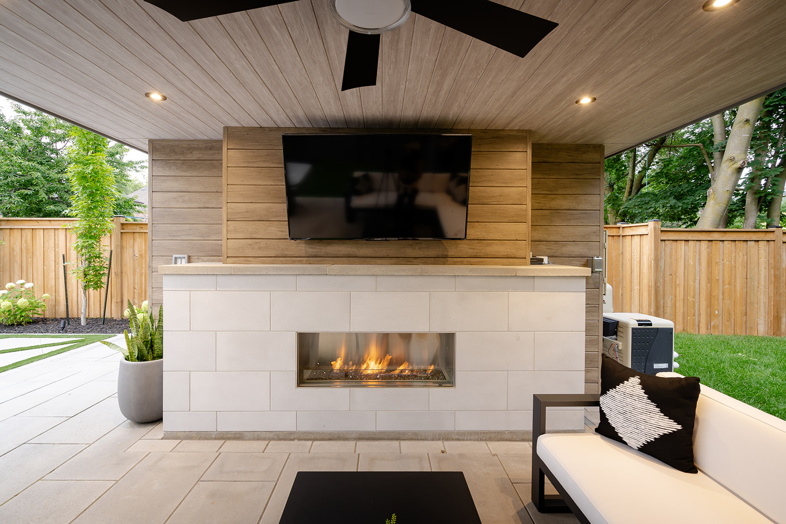 A fireplace in the wall with a tv mounted to the wall with seating.