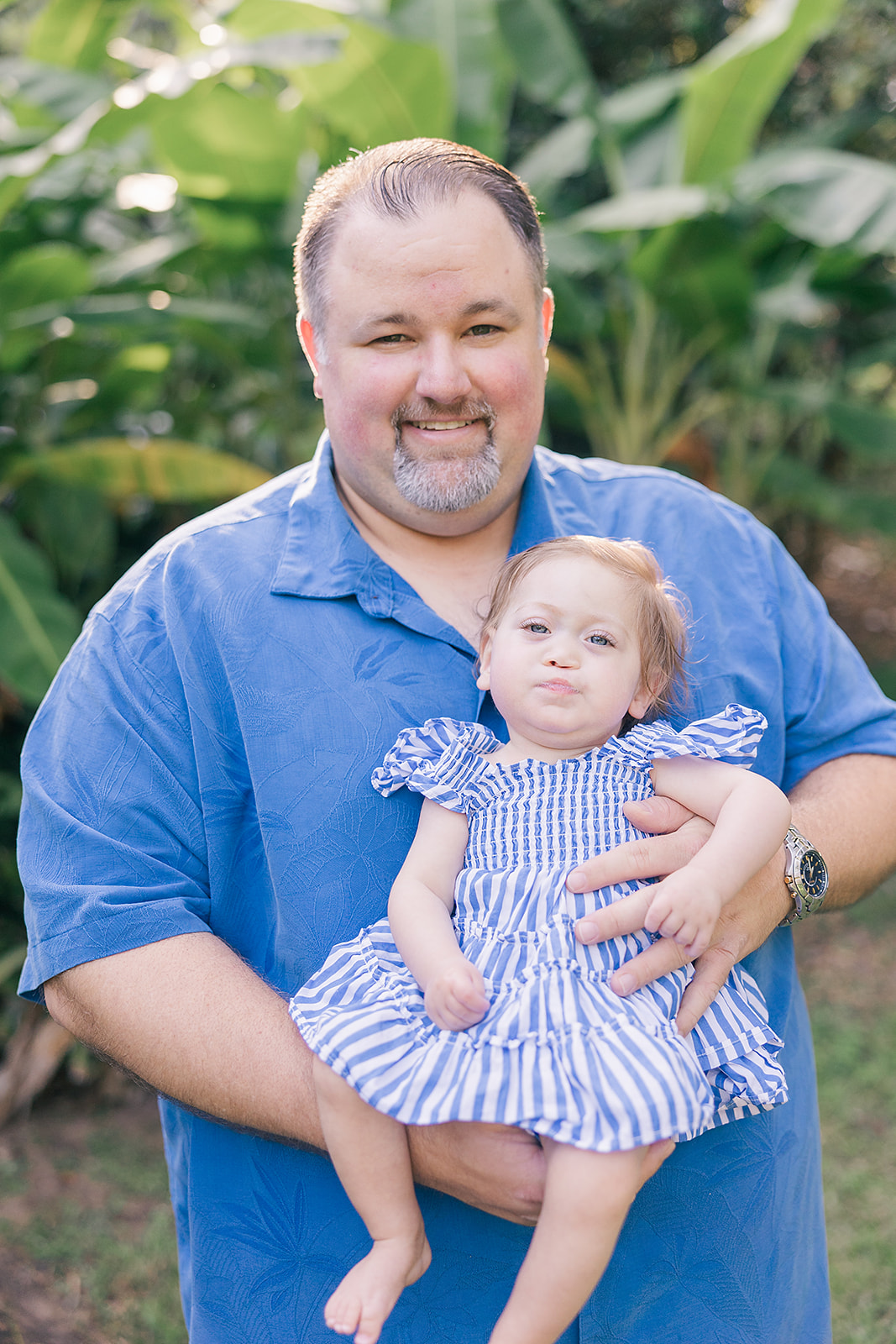 12 month baby girl with bright blue eyes and her dad, in a bright blue shirt