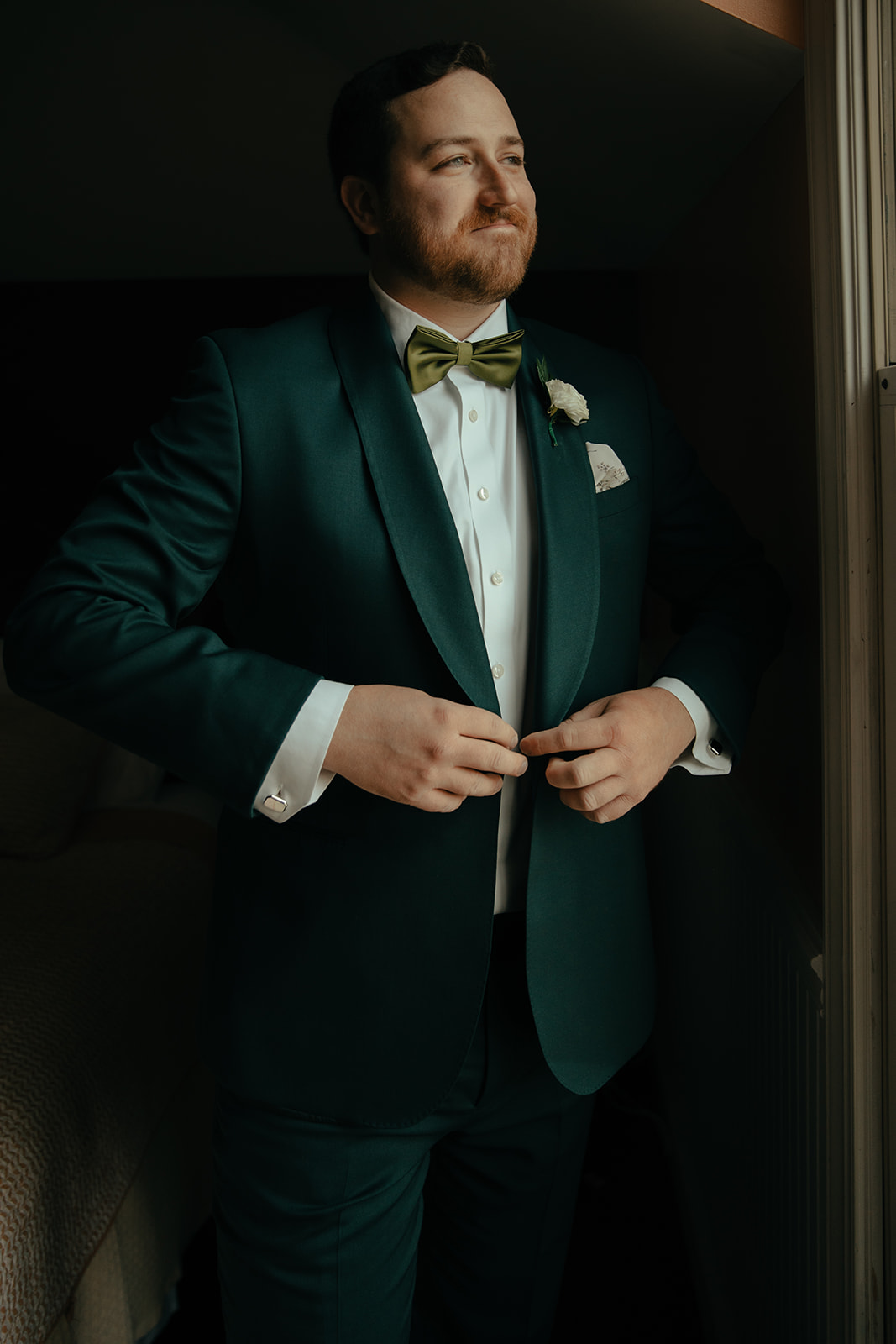 Groom in emerald green suit with green bowtie getting ready at County Clare Milwaukee