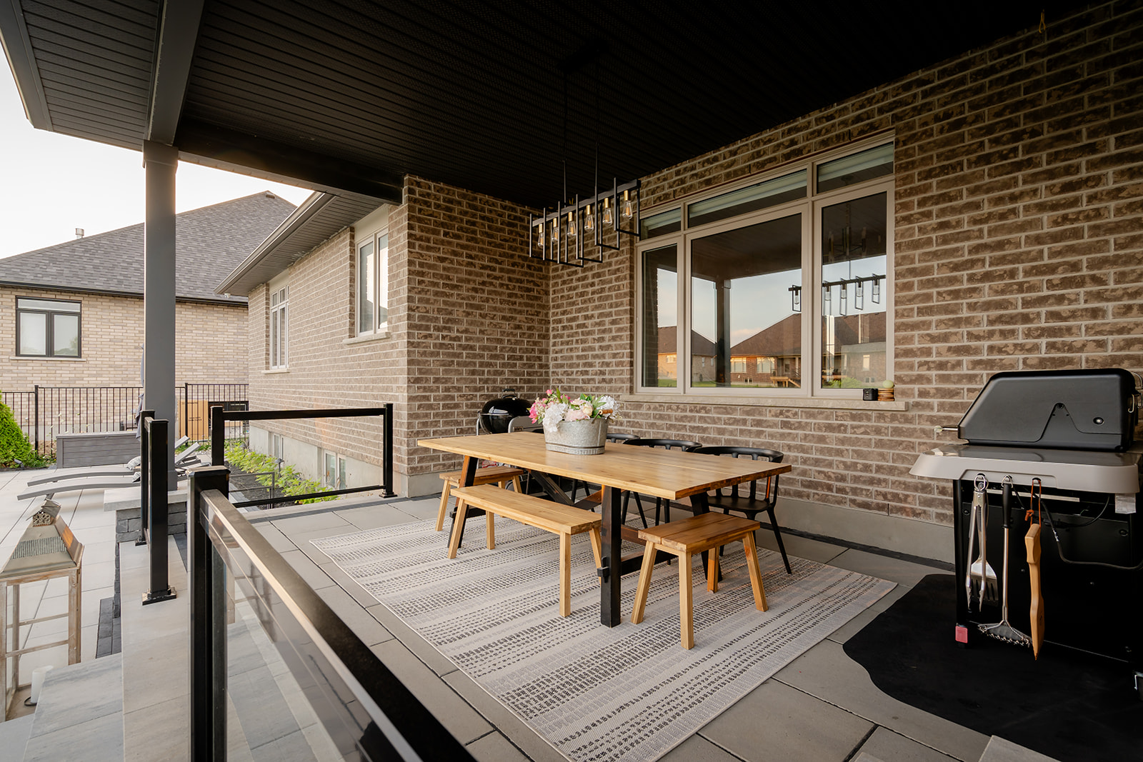 An outdoor seating area with a barbeque on the side.