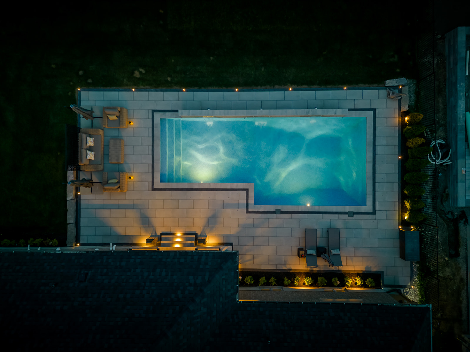 Top down view with lights on in the inground pool.