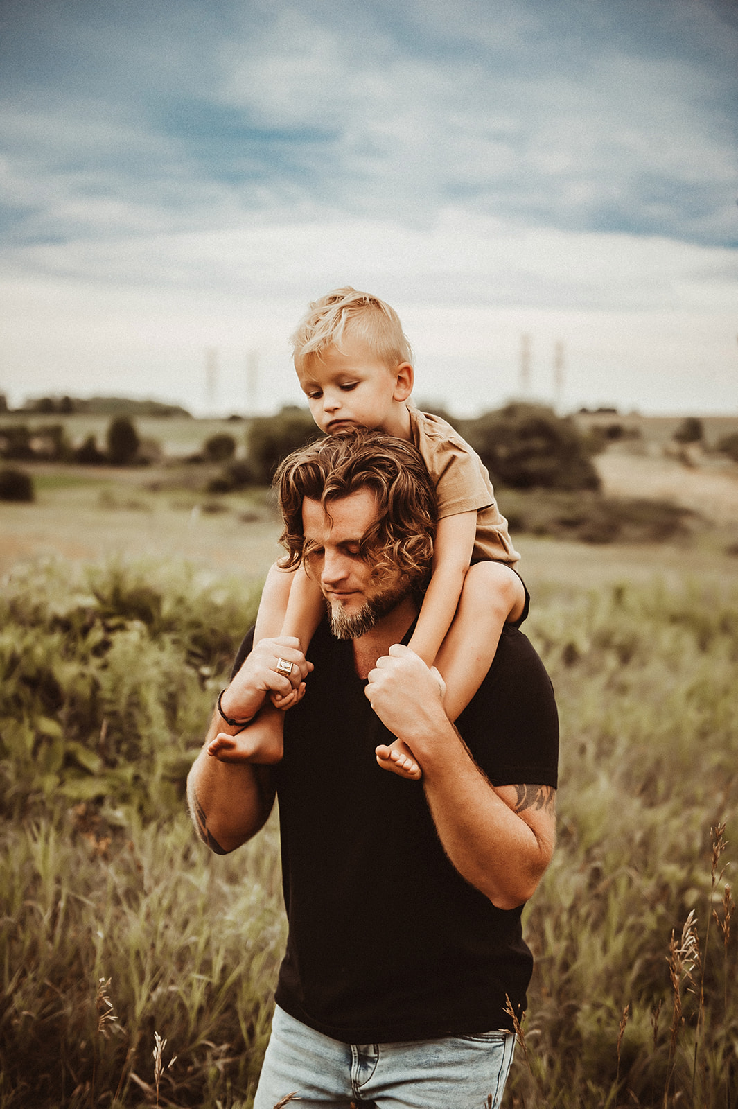 father carrying his son across a field in the durham region