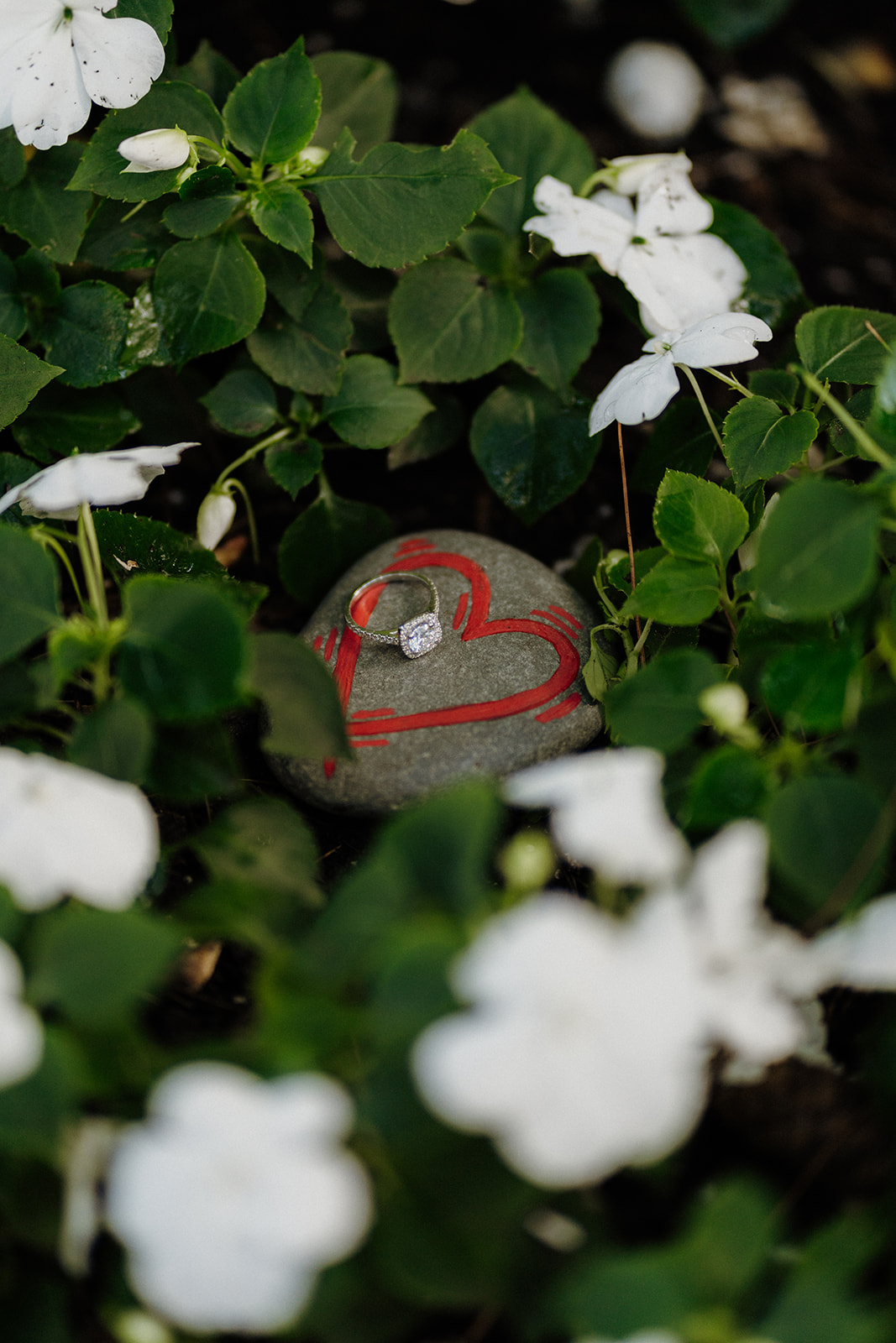 a ring on a rock with a red heart painted.
