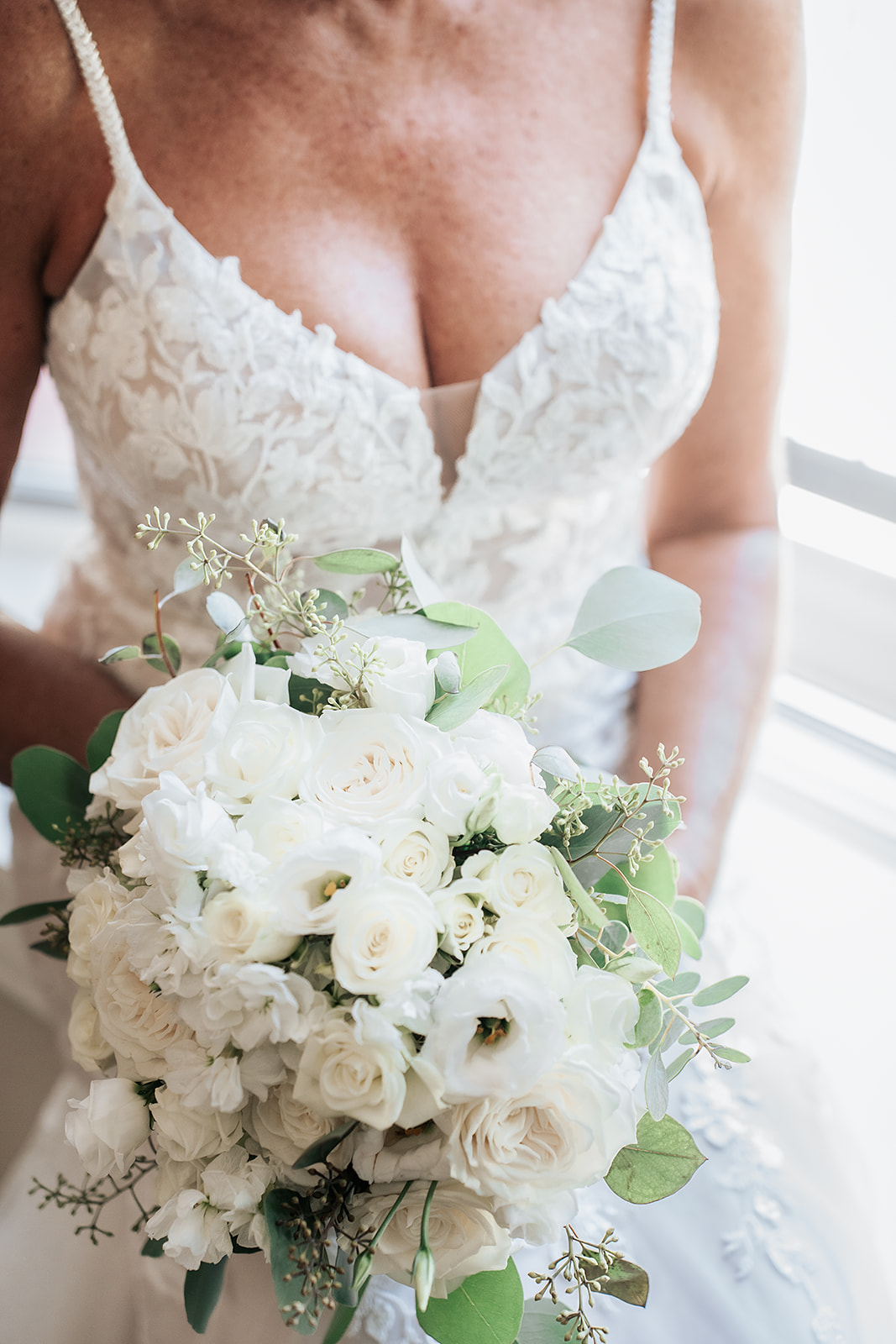 Artistic shot of bridal bouquet and dress
