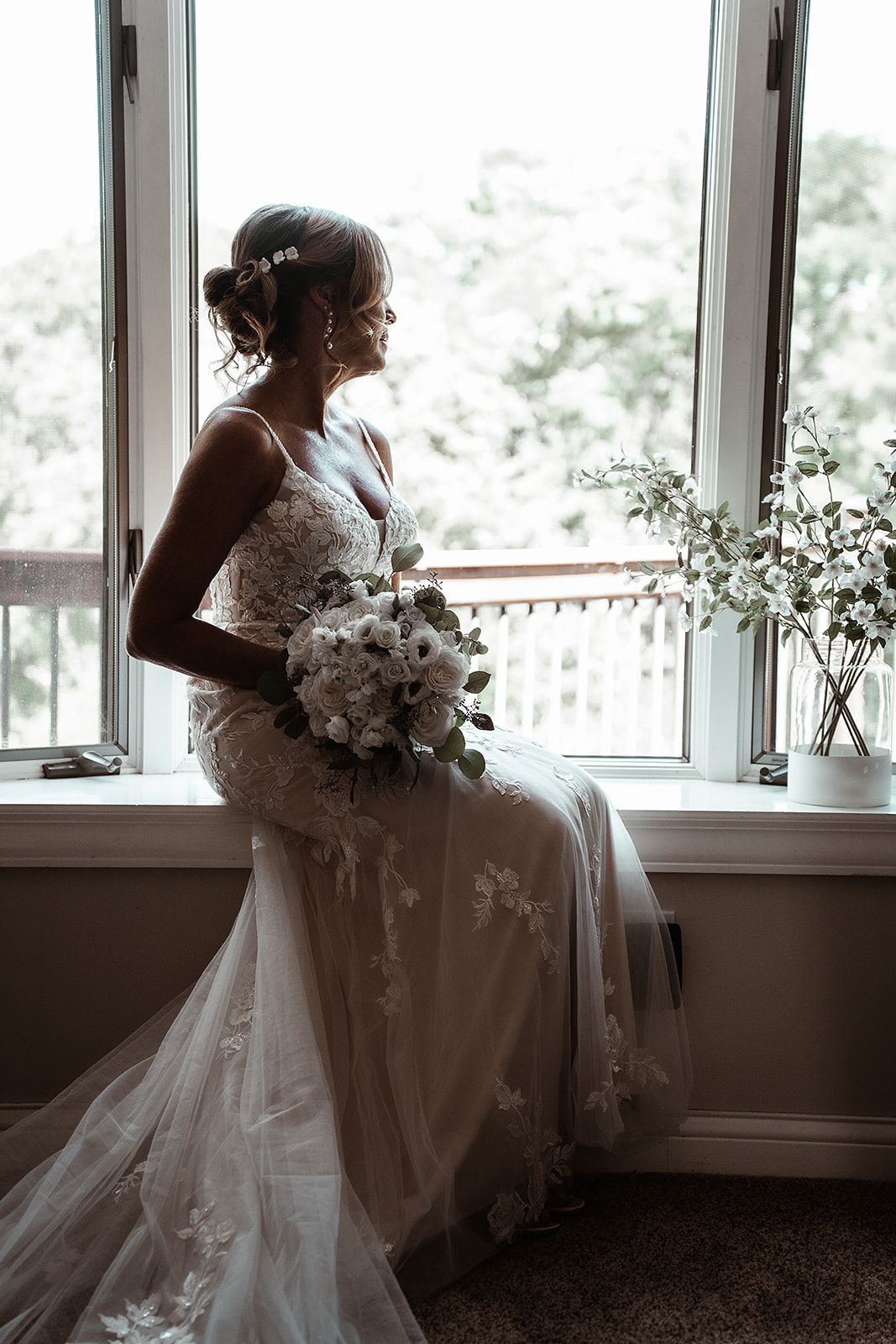 Artistic shot of bride looking out window