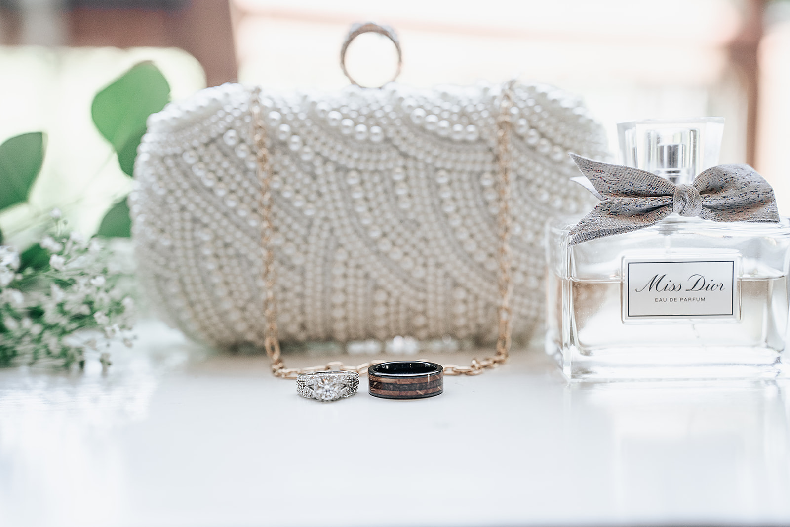 Artistic shot of brides purse and wedding rings