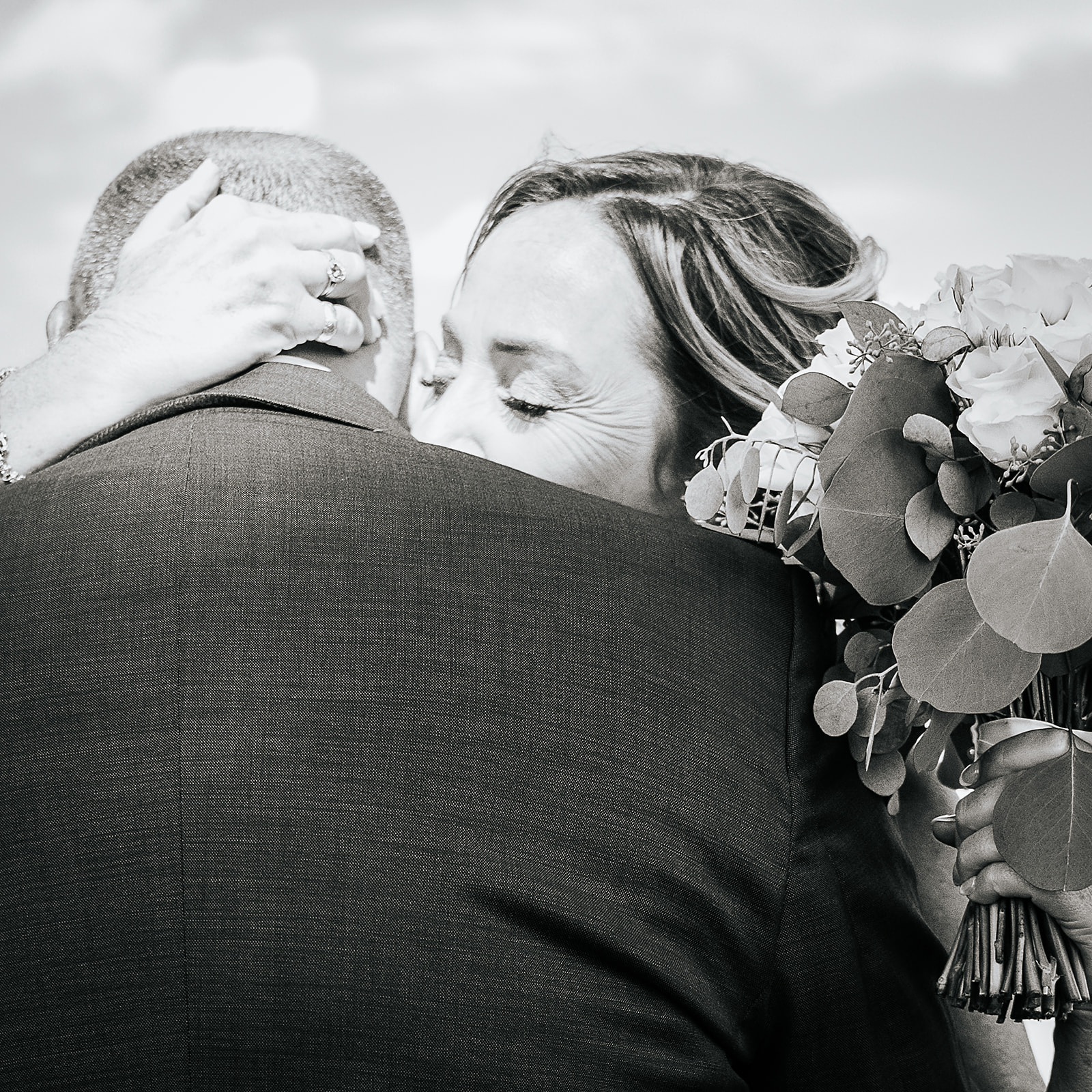 Black and white couple hugging after first look