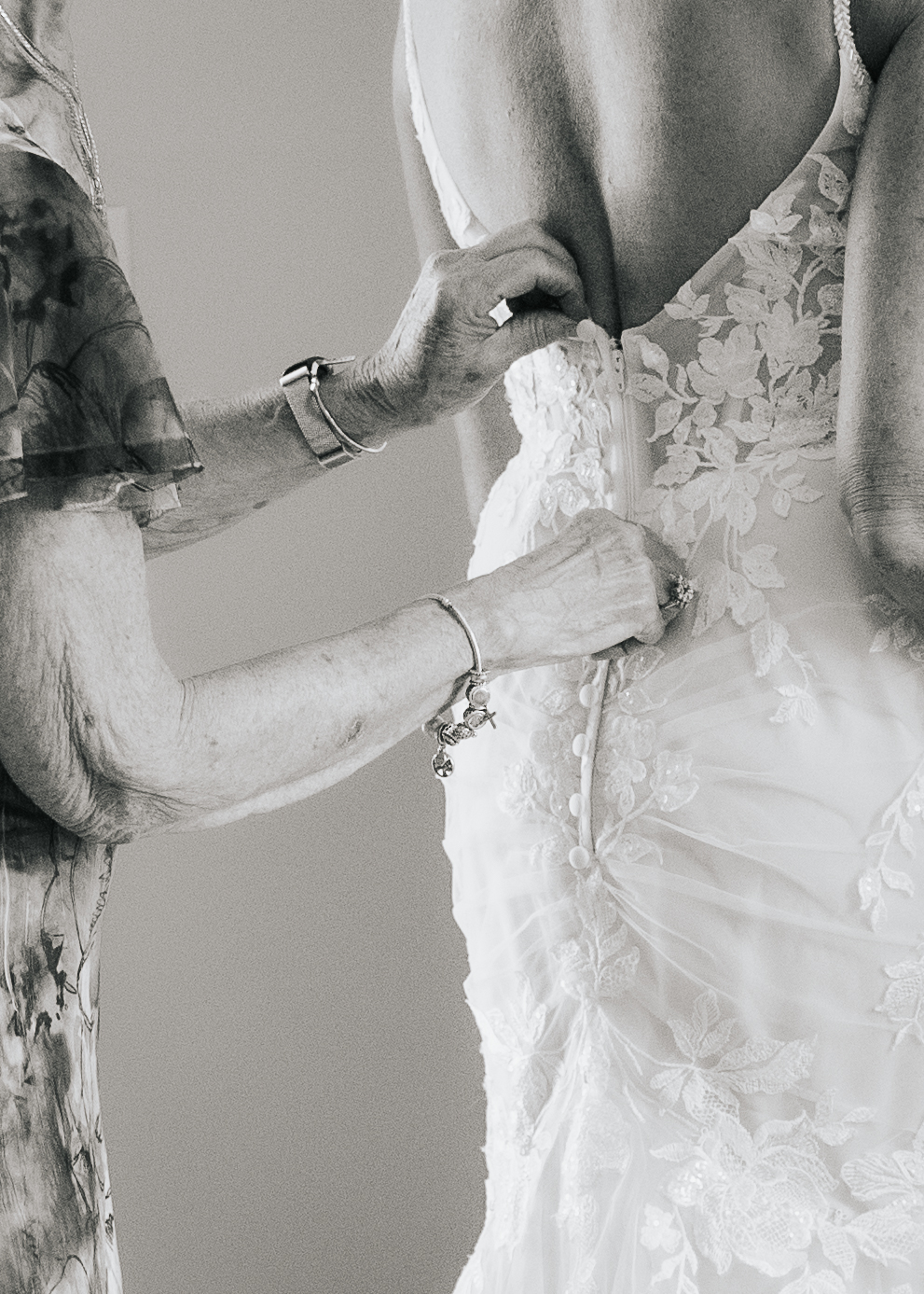 Black and white image of mother and bride close up of dress detail