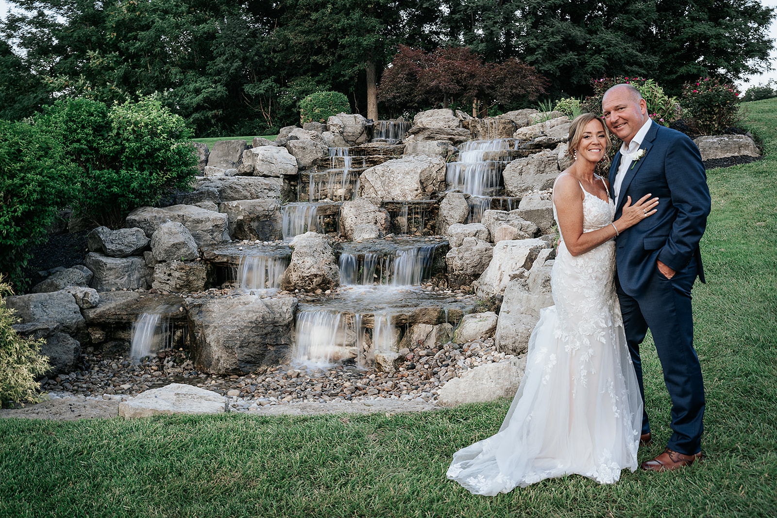 Couple just married in front of waterfall at Aston Oaks Golf Club