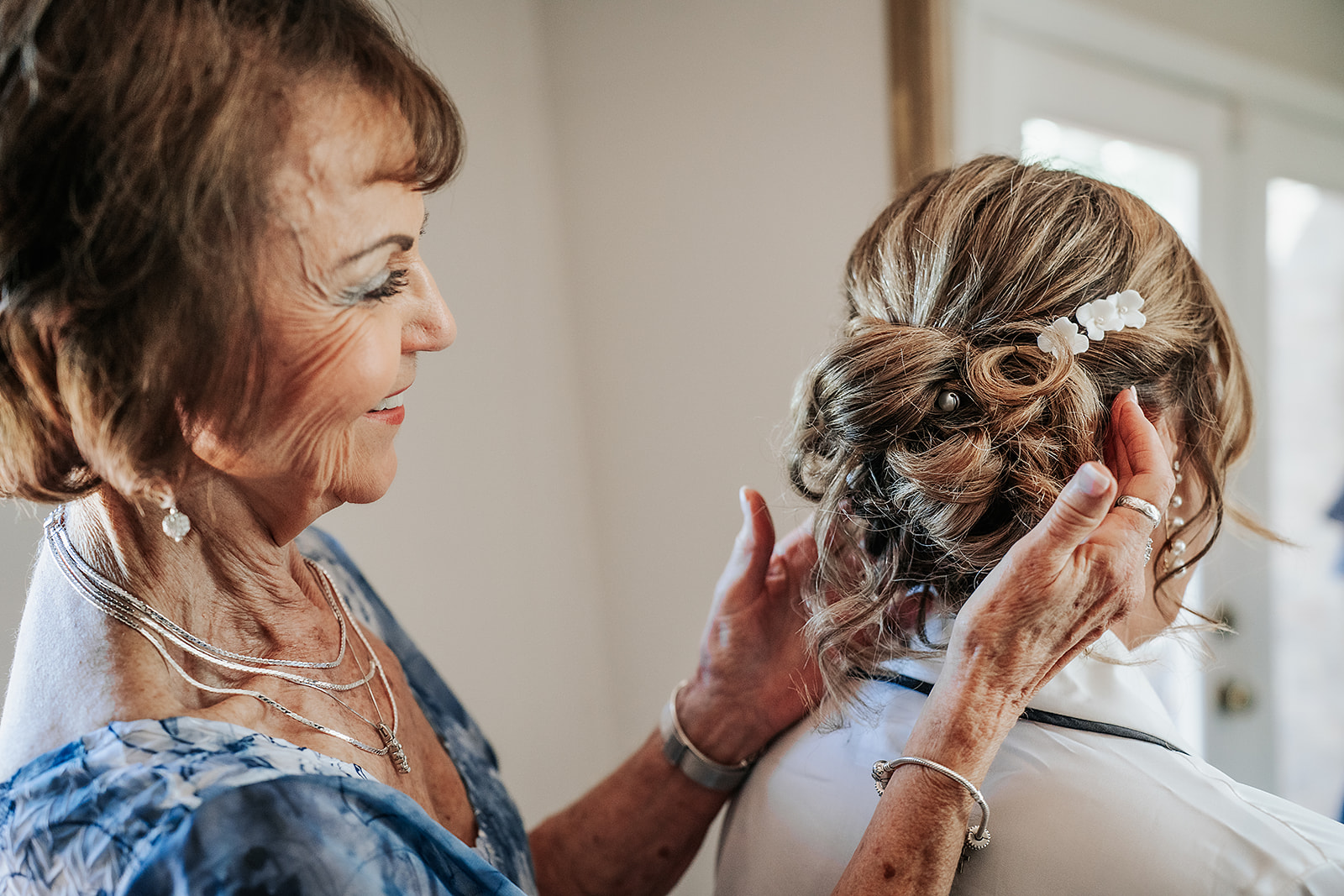 Mother of bride fixing bride's hair