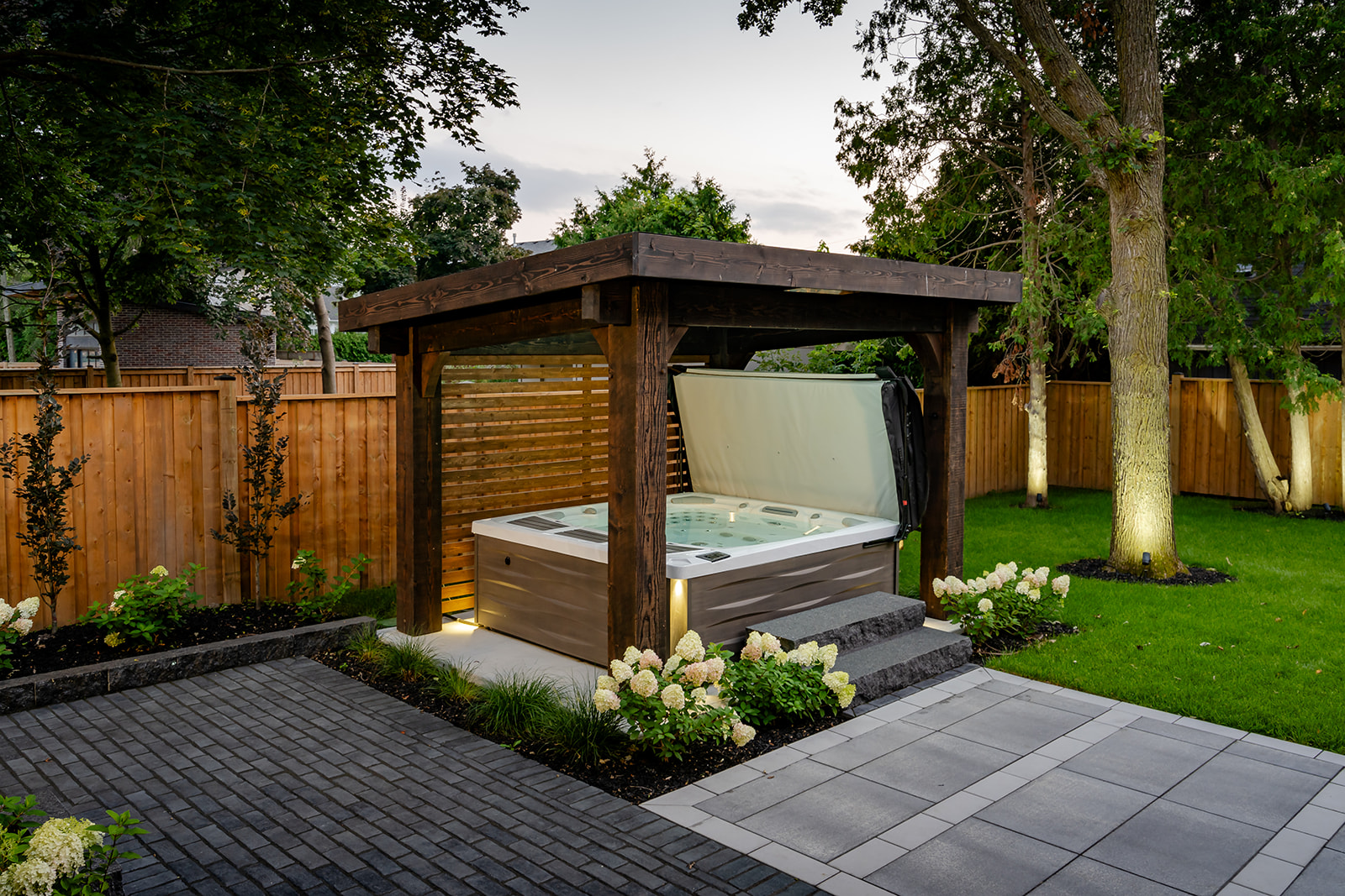 An open jacuzzi underneath a wooden canopy.