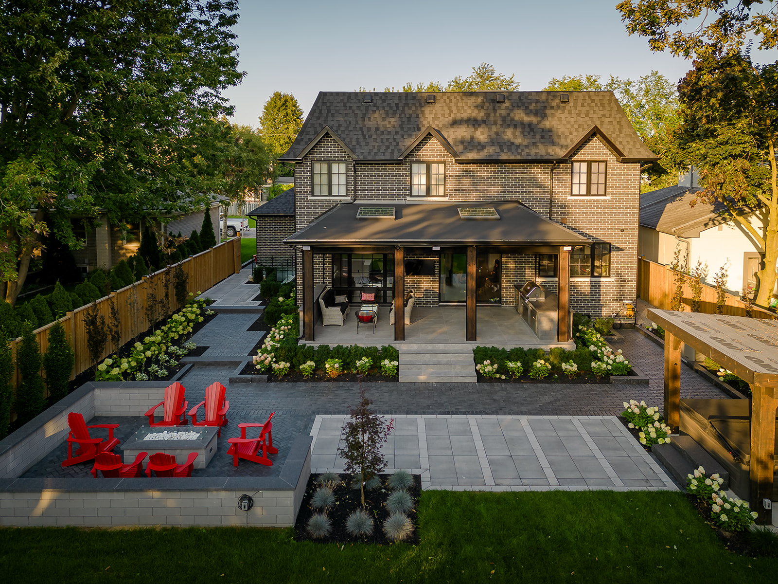 A patio setup with Muskoka chairs on the left and a hot tub on the right.