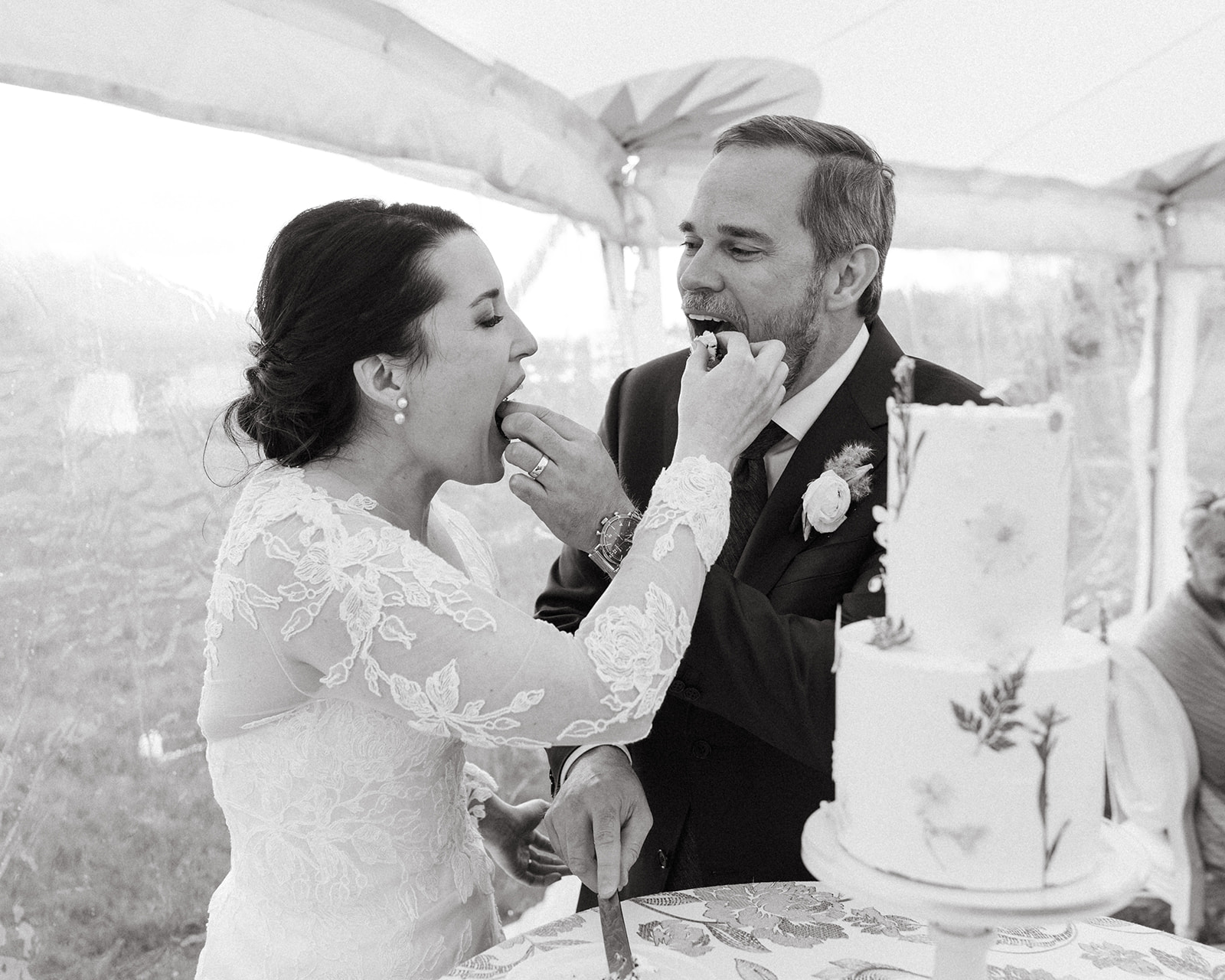 A bride and groom share a piece of cake during their cake-cutting at their ranch reception in Wyoming.