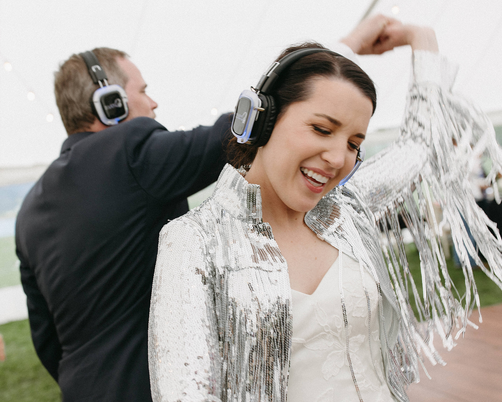 A groom twirls his bride while dancing at their silent disco wedding reception in Jackson Hole, Wyoming. 
