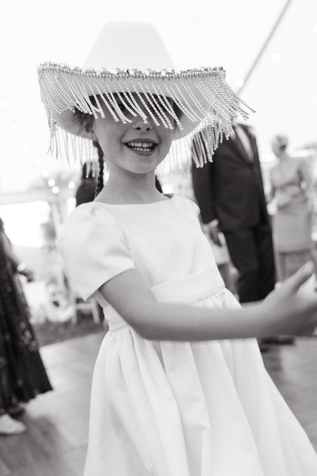A flower girl, wearing a fringe cowboy hate, danced during a silent disco wedding reception at a ranch. 
