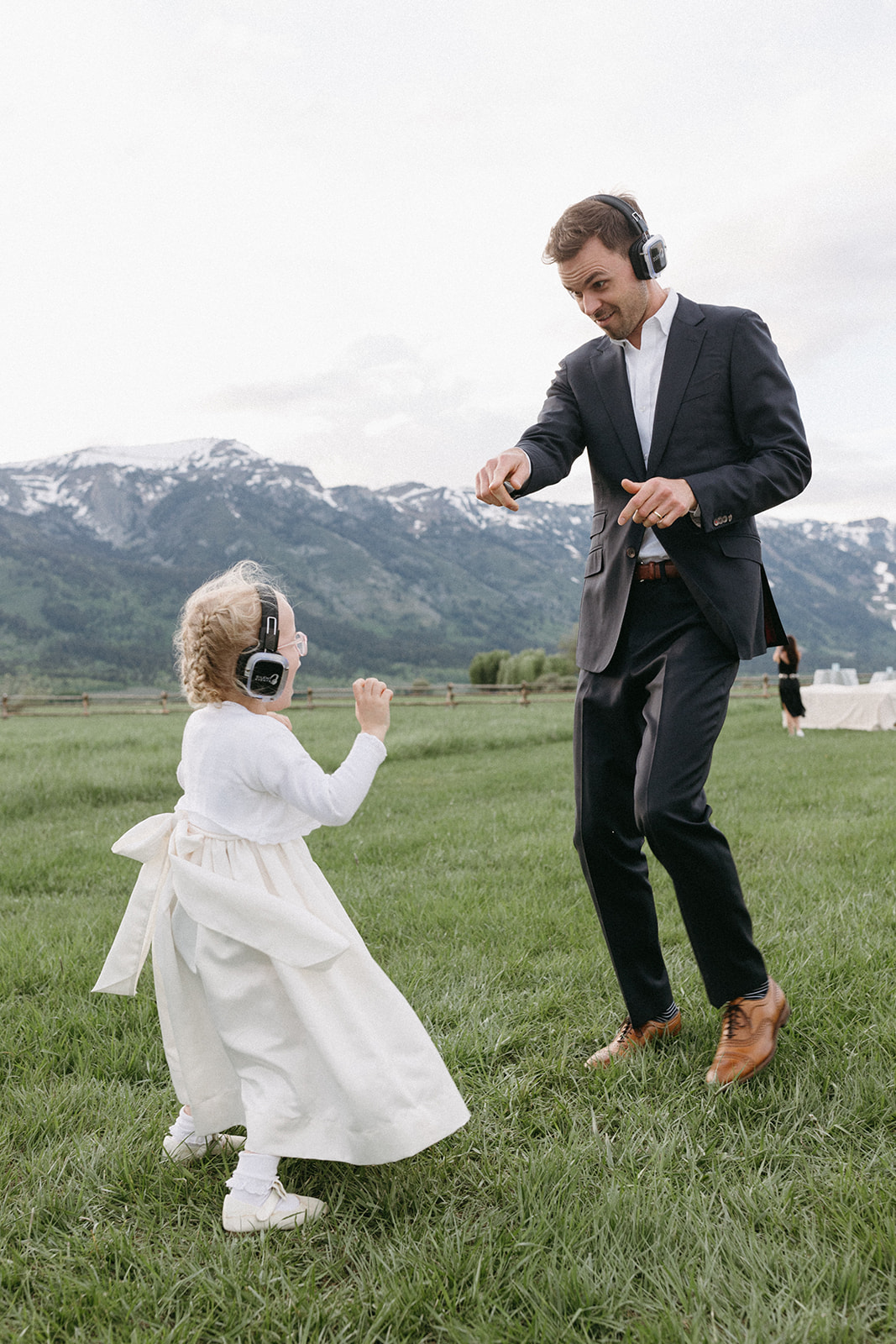 Two wedding guests dance in a field during a silent disco wedding reception at a Wyoming ranch. 
