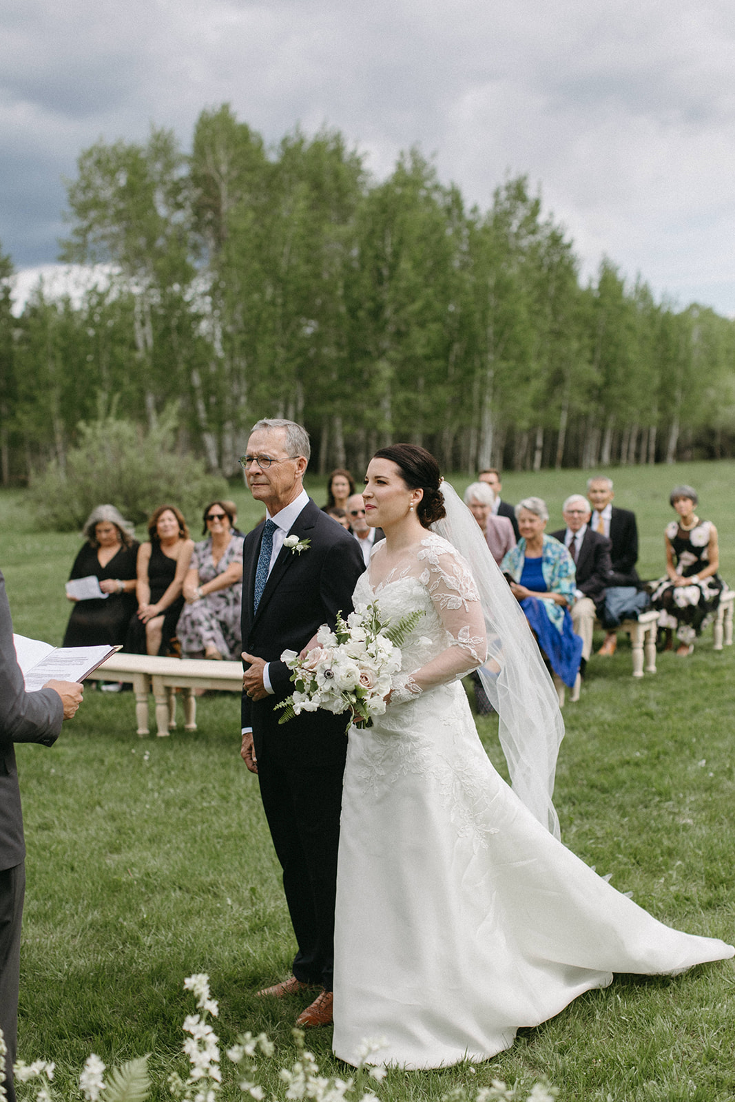 A father of the bride walks his daughter down the aisle during a Snake River Ranch wedding in Wyoming. 