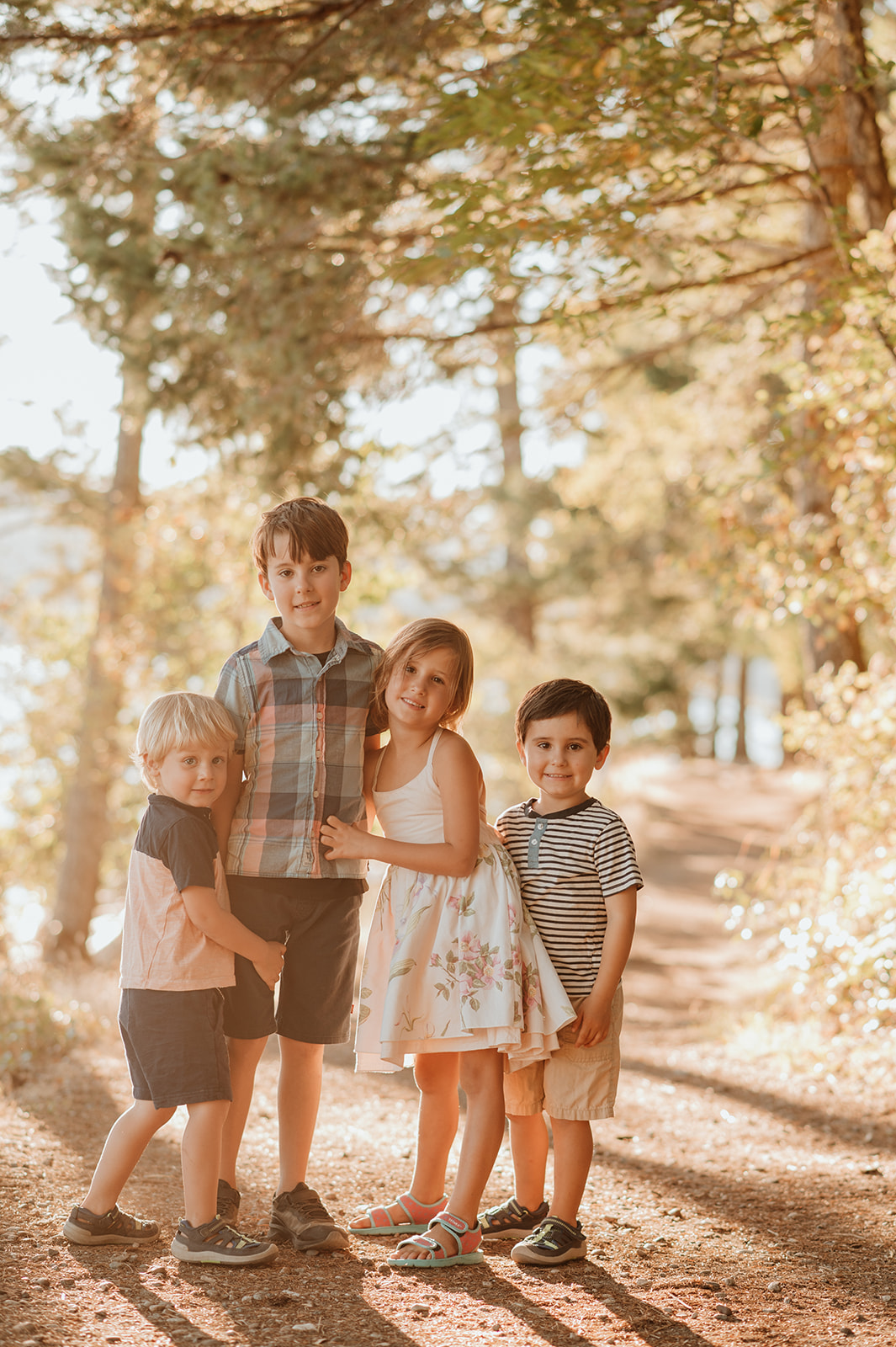 4 children snuggling in the forest at their vancouver island family photography session