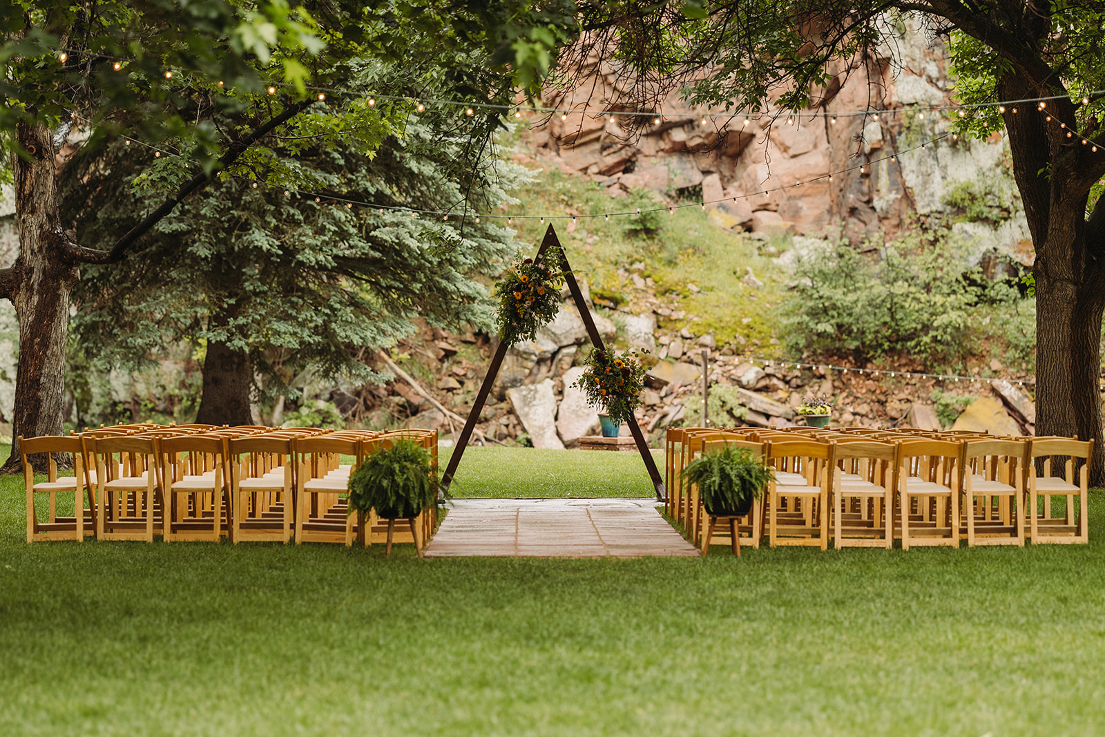 The ceremony setup for this River Bend wedding, featuring  a wooden A-frame at the altar and sandstone cliffs behind.