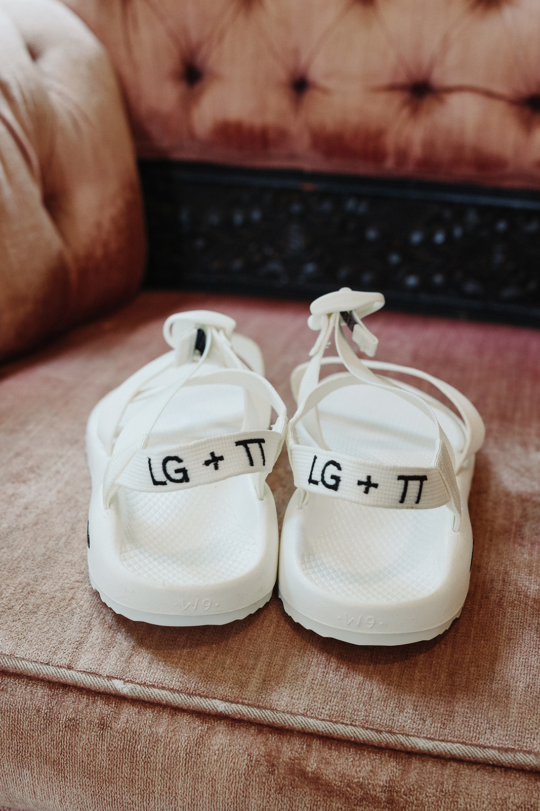 The bride's custom white Chaco sandals with her and her fiance's initials embroidered onto the back strap.