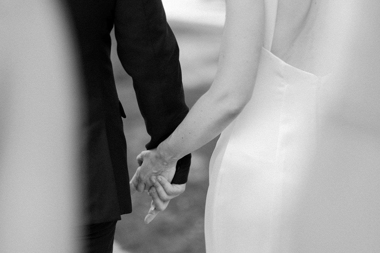 Bride and groom hold hands.