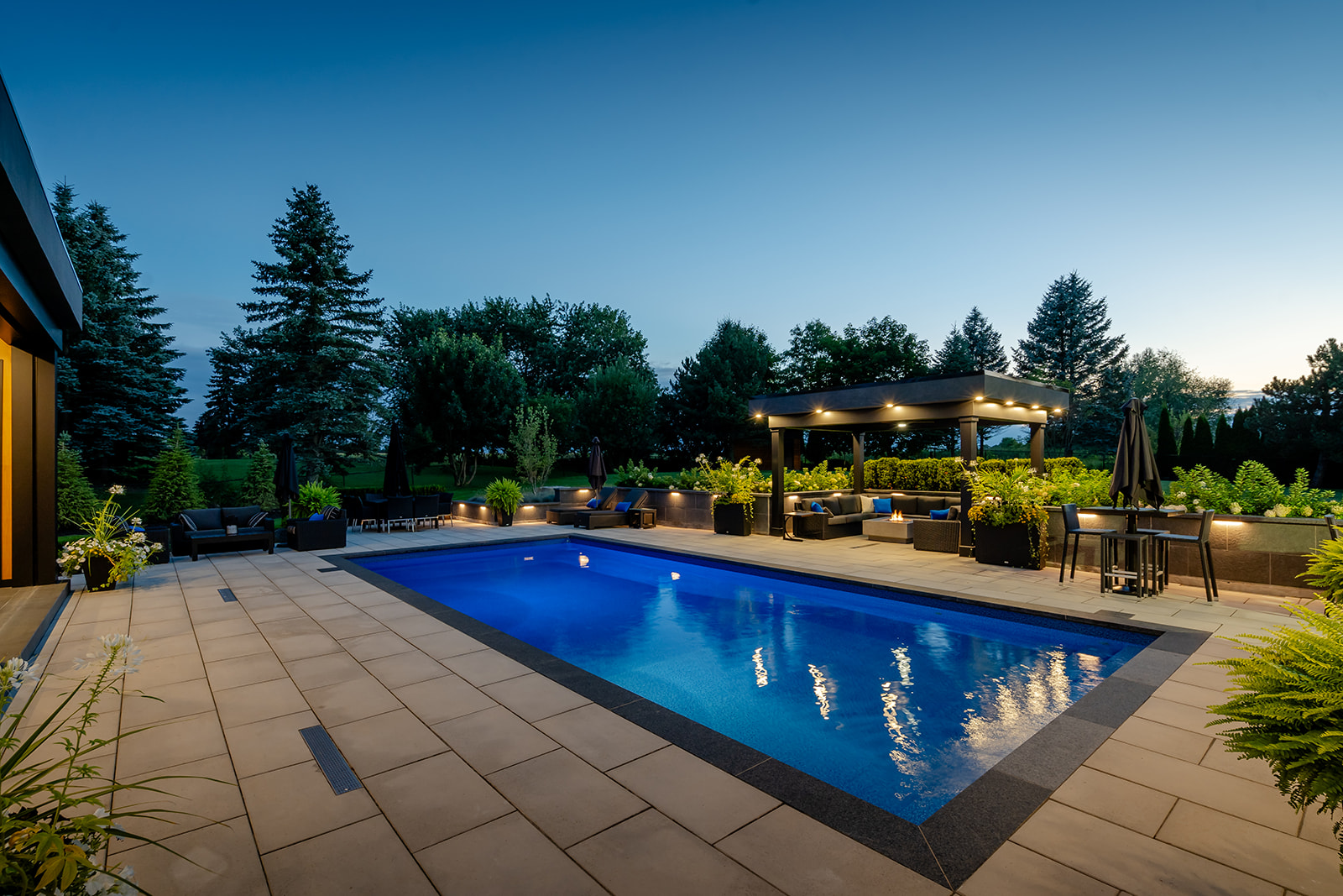 A rectangular inground pool surrounded by patio stones.