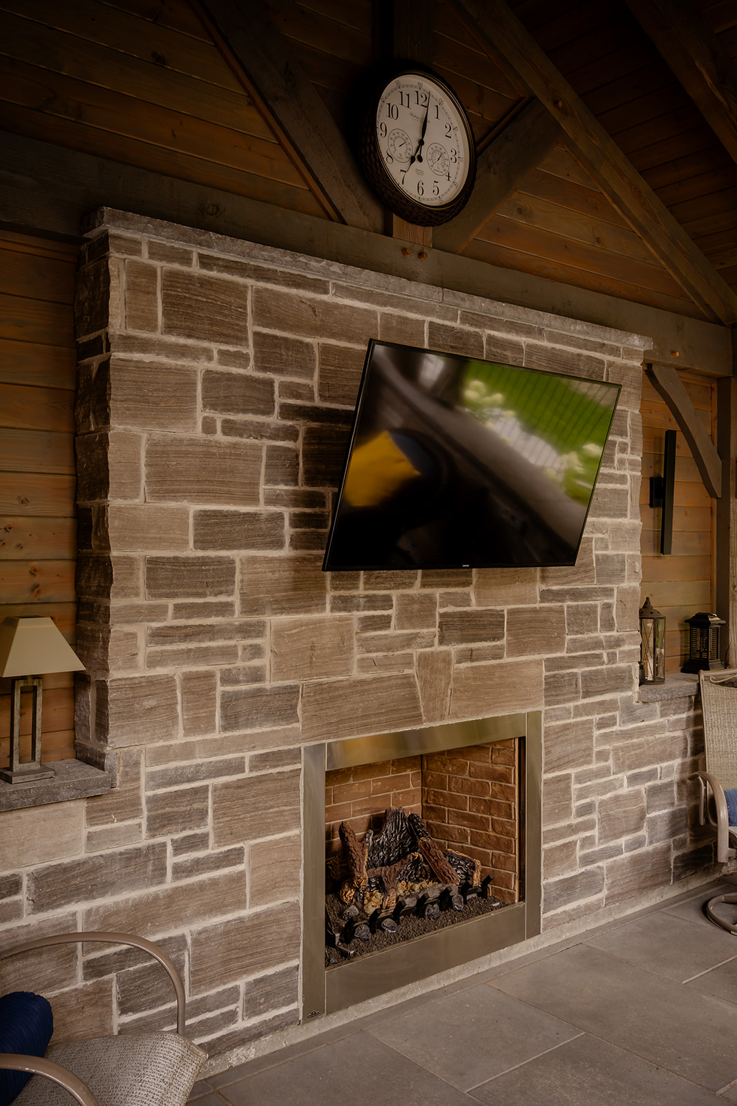A TV mounted to the wall above a fireplace.