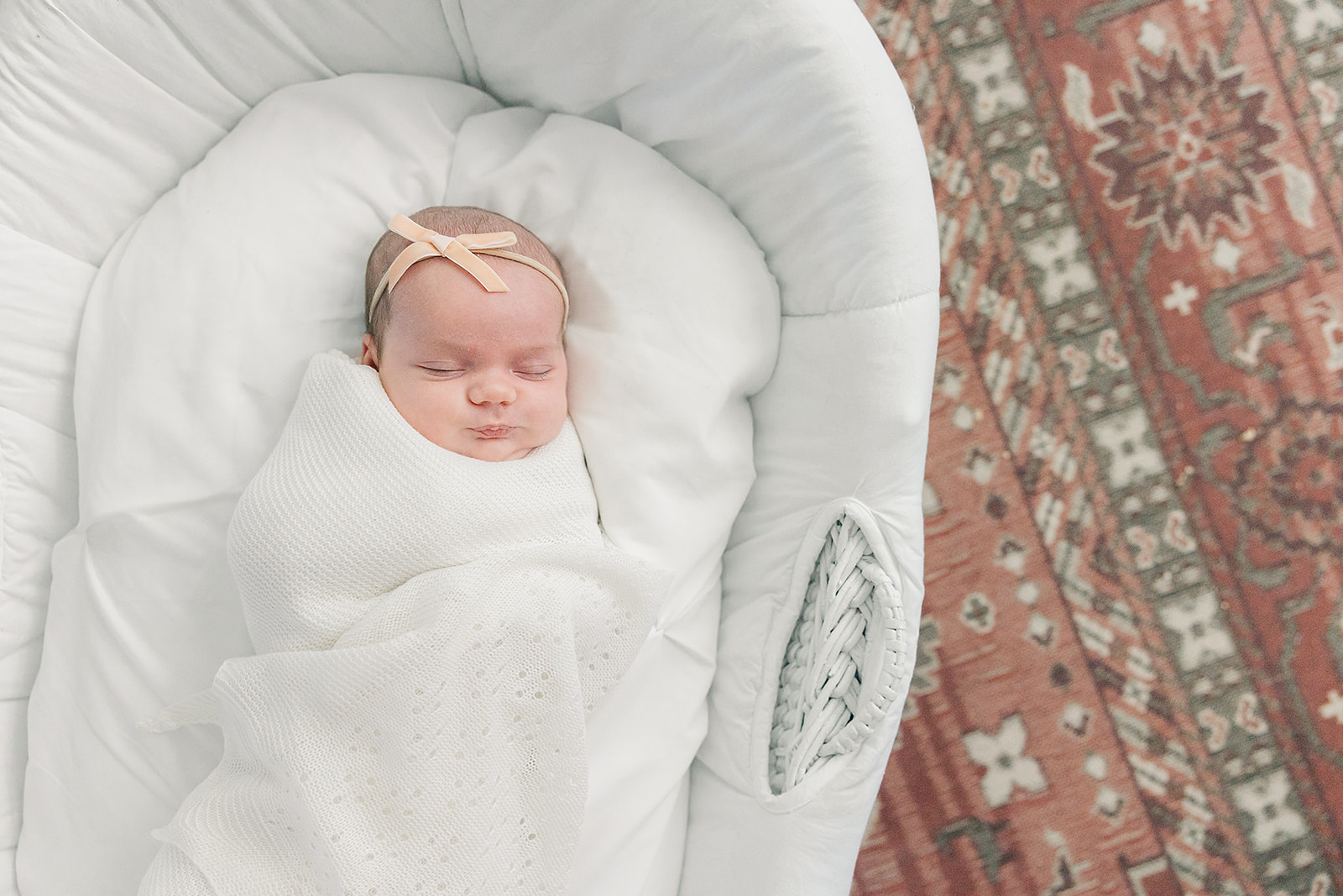 newborn baby girl in moses basket on Turkish rug
