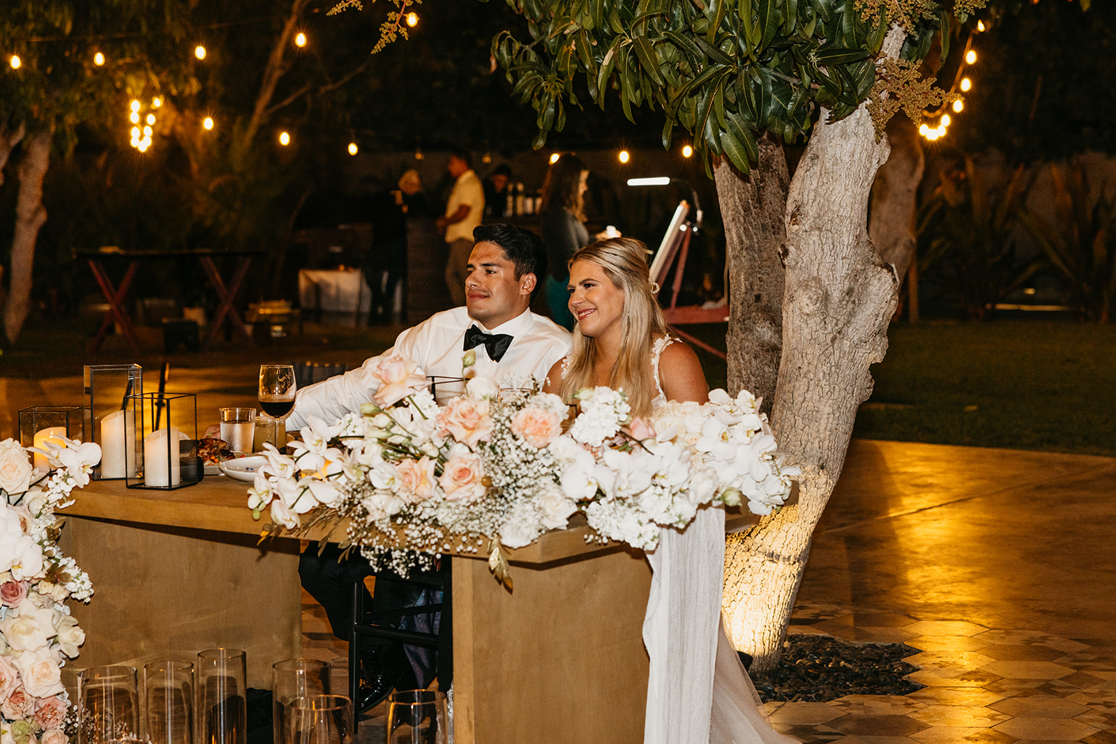 Bride and groom hear speeches during their reception at Acre Resort Cabo
