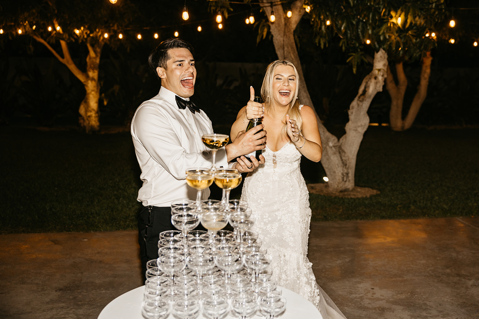 Bride and groom pour a champange tower during their wedding reception at Acre Resort in Cabo San Lucas Mexico