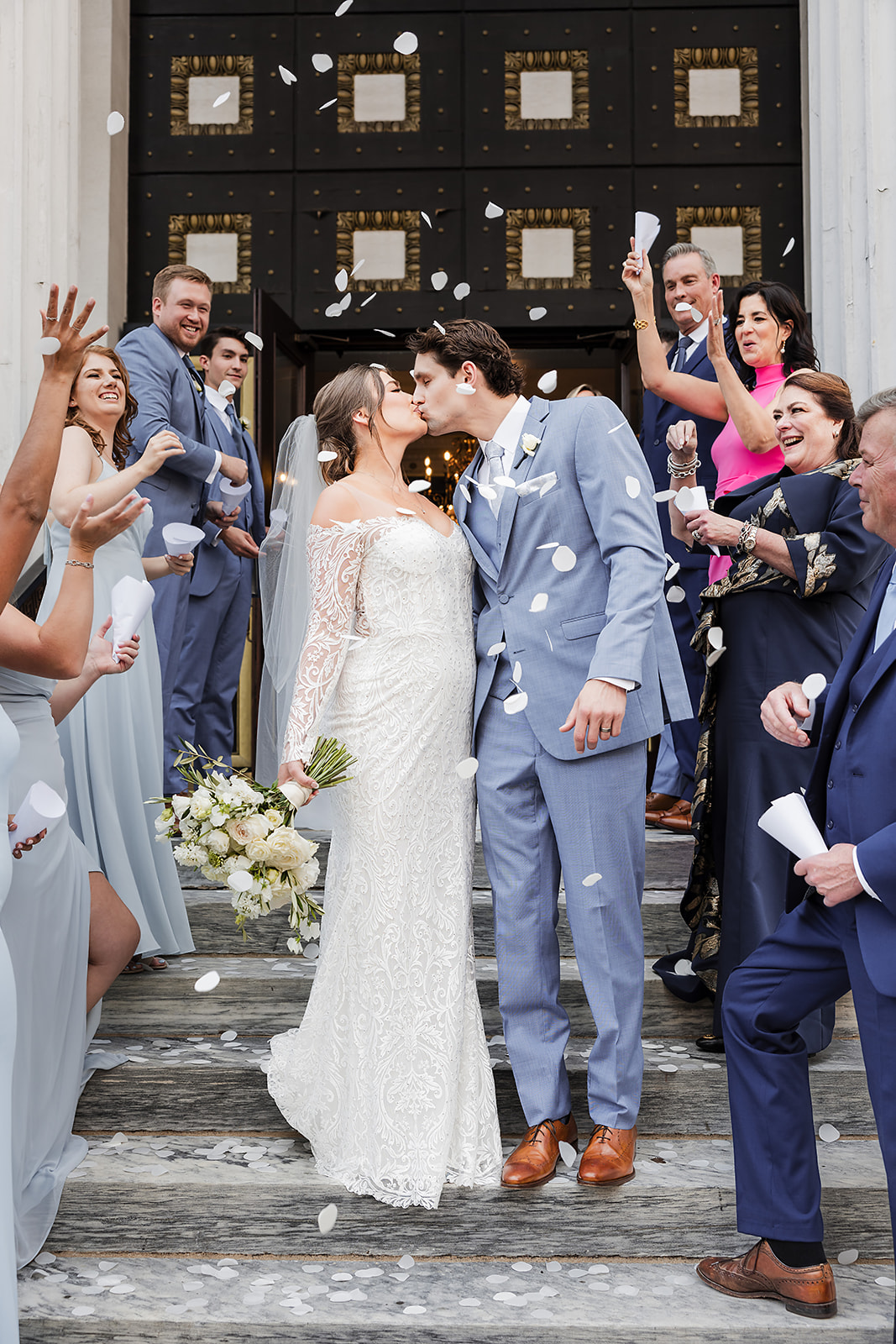 Bride and groom kissing on the steps of St. George Greek Orthodox Cathedral in Philly after wedding ceremony