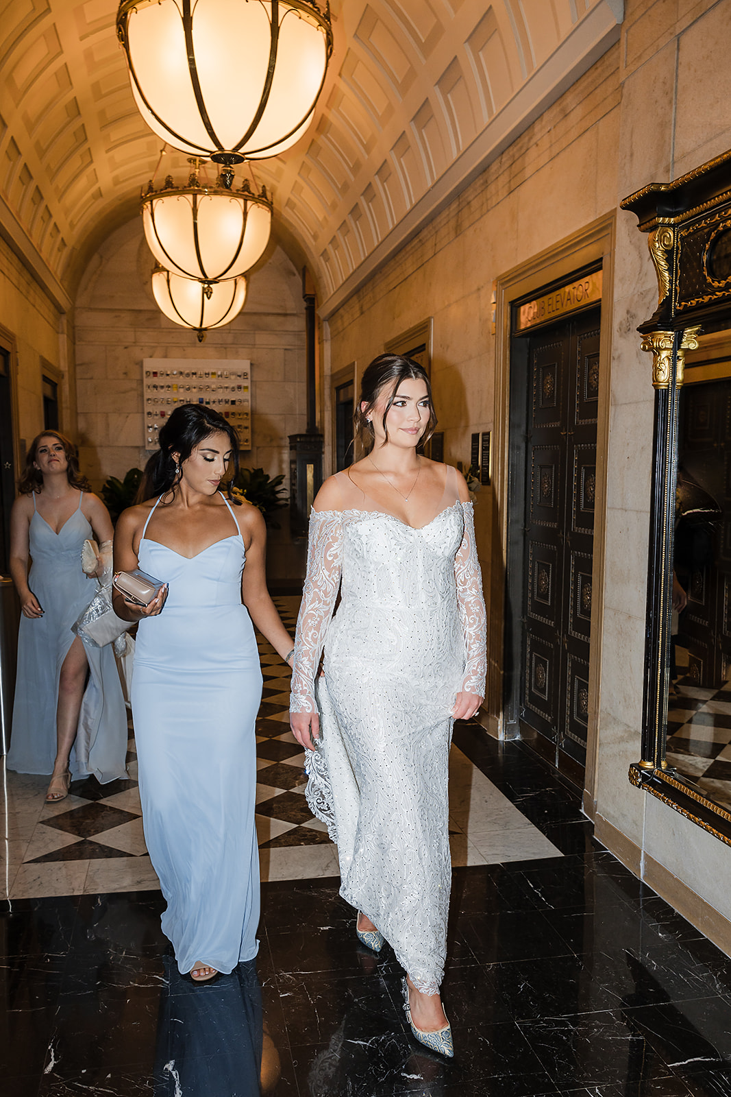 Bride walking from the elevator at Ritz Carlton in Philadelphia wearing Pnina Tornai off shoulder long sleeve dress