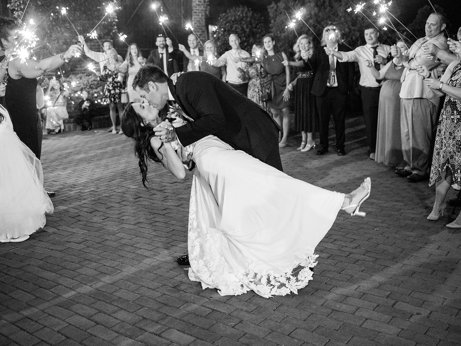 black and white photo of Maggie and rich at their sparkler exit leaving the silk mill
