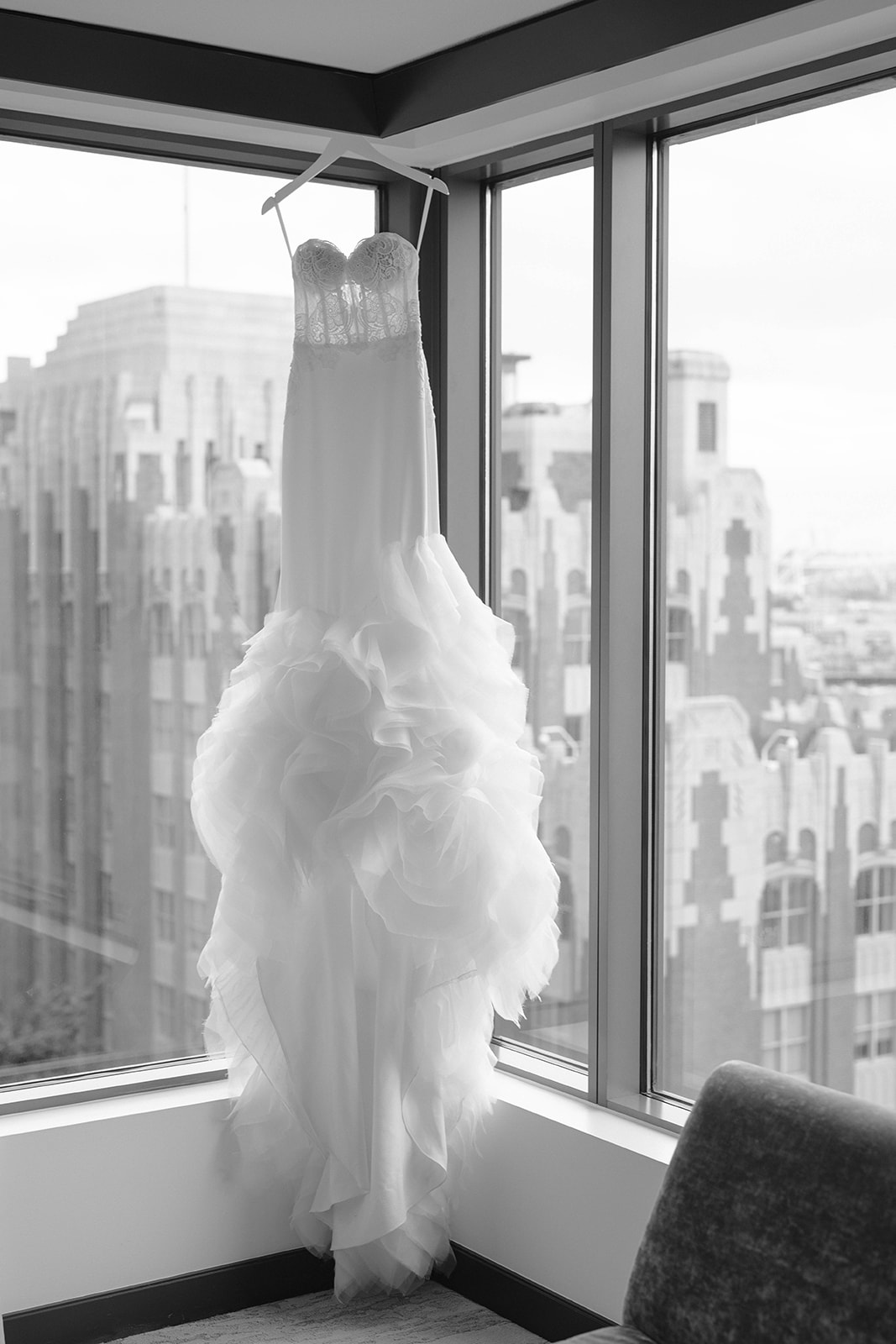white, romantic wedding dress hangs in window
