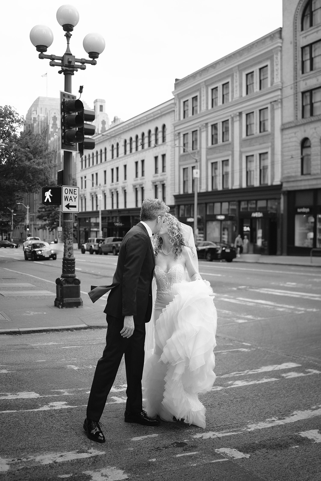 bride and groom kiss in the middle of the street