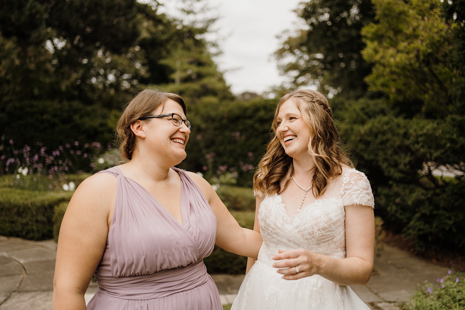 Bride smiling with bridesmaid.