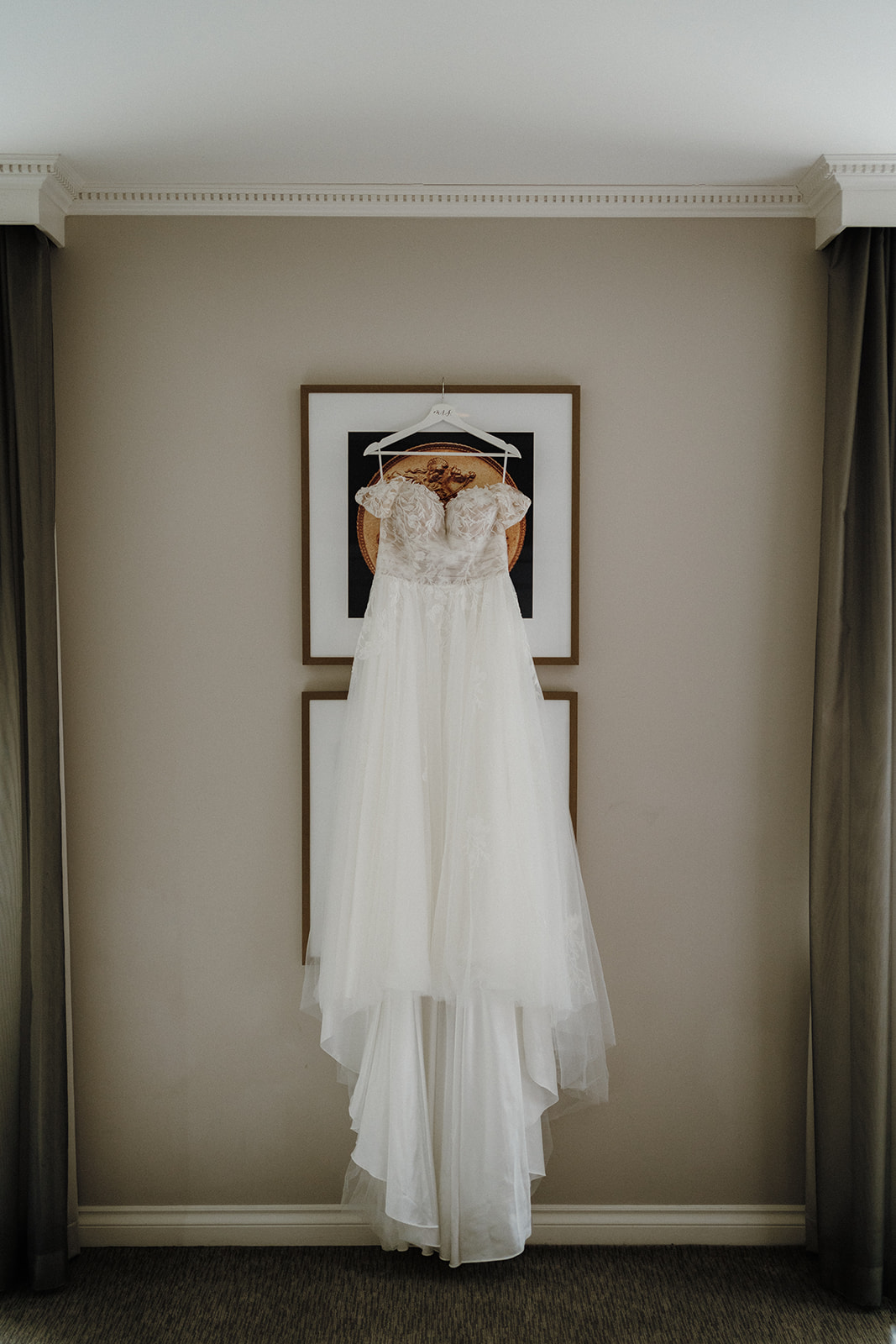 A wedding dress hanging on the wall.