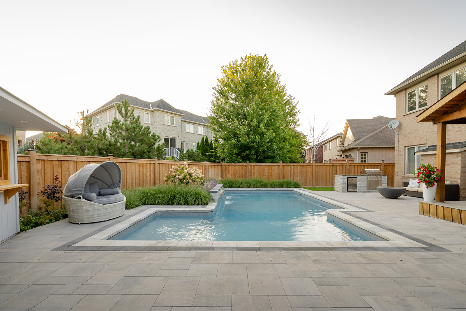 An inground pool with seating areas around.