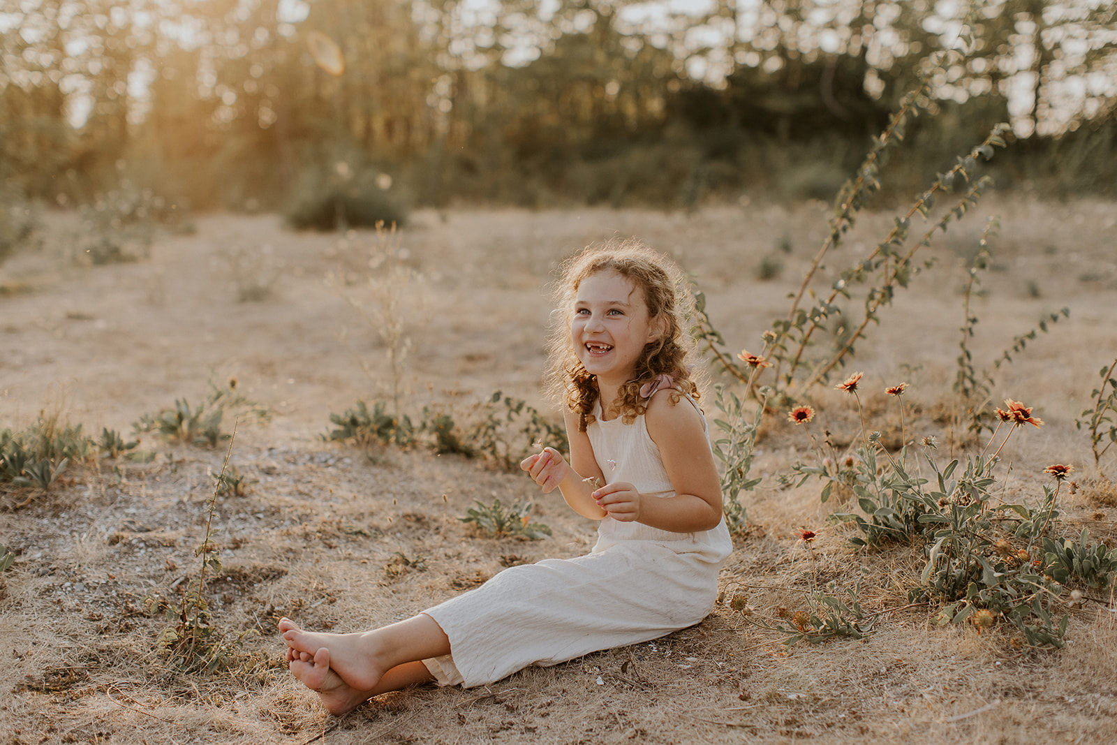 little girl holding a flower smiling