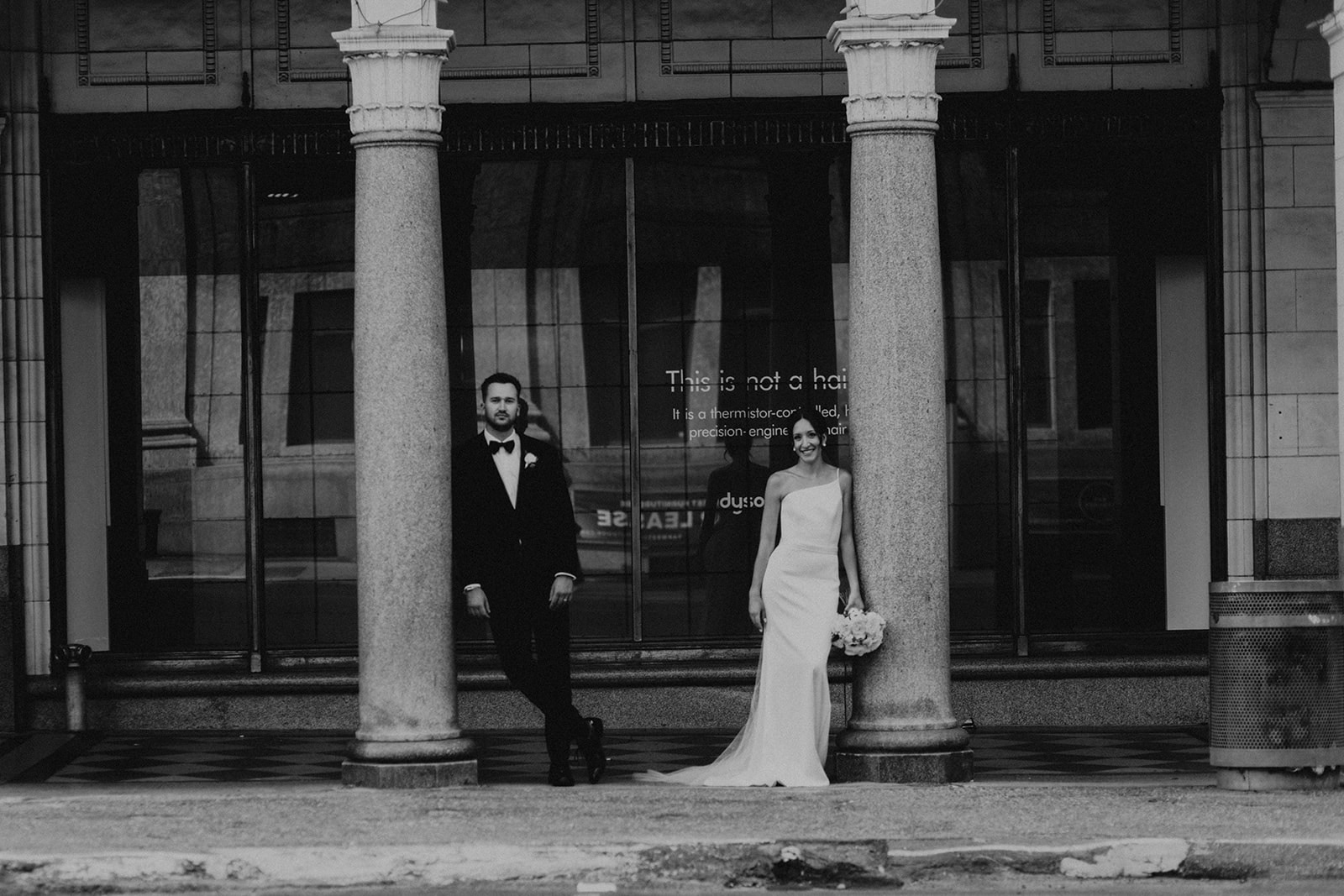 Bride and groom standing at Hudson's bay arches Calgary 