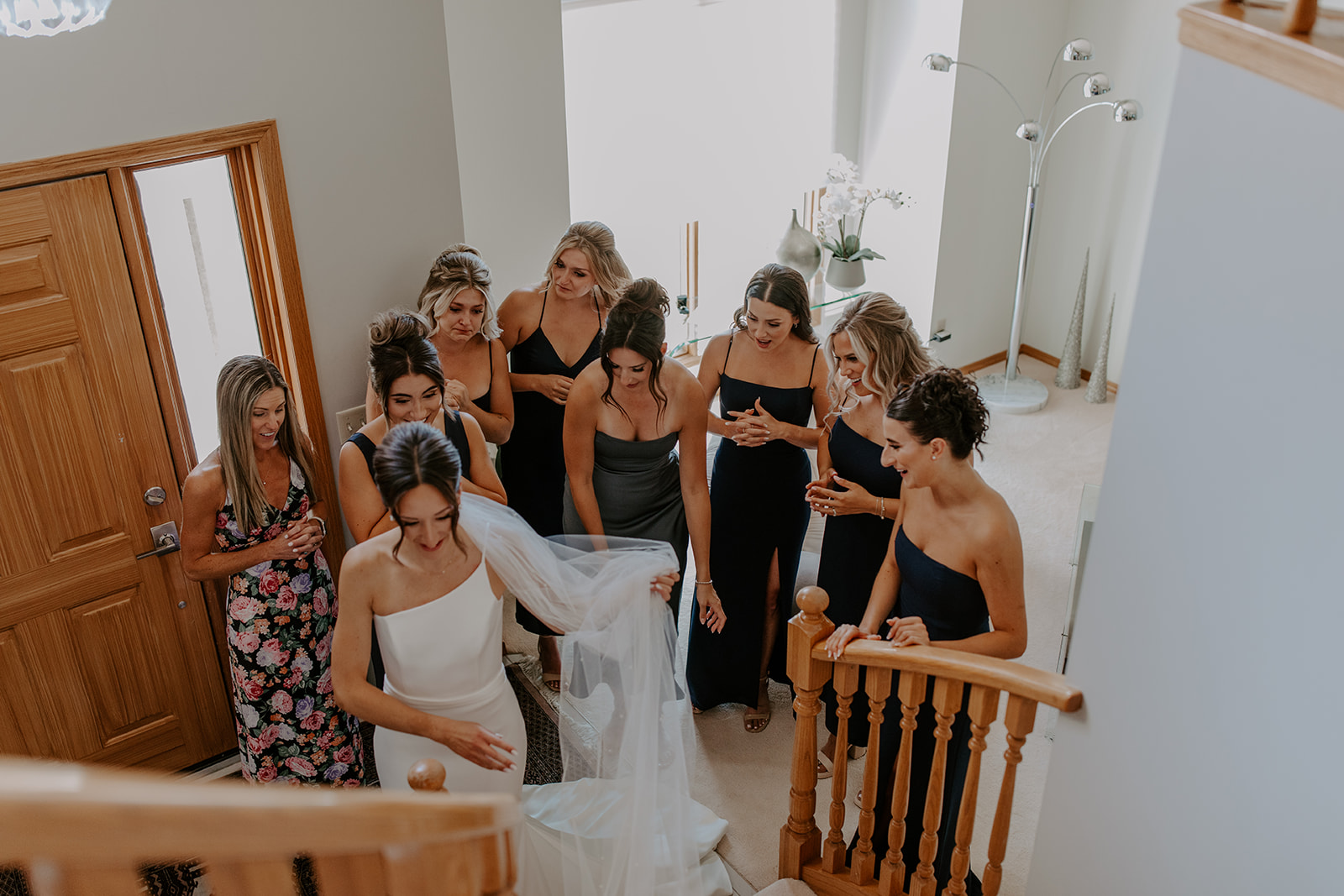 Bride showing her dress to her bridesmaids on her wedding day 