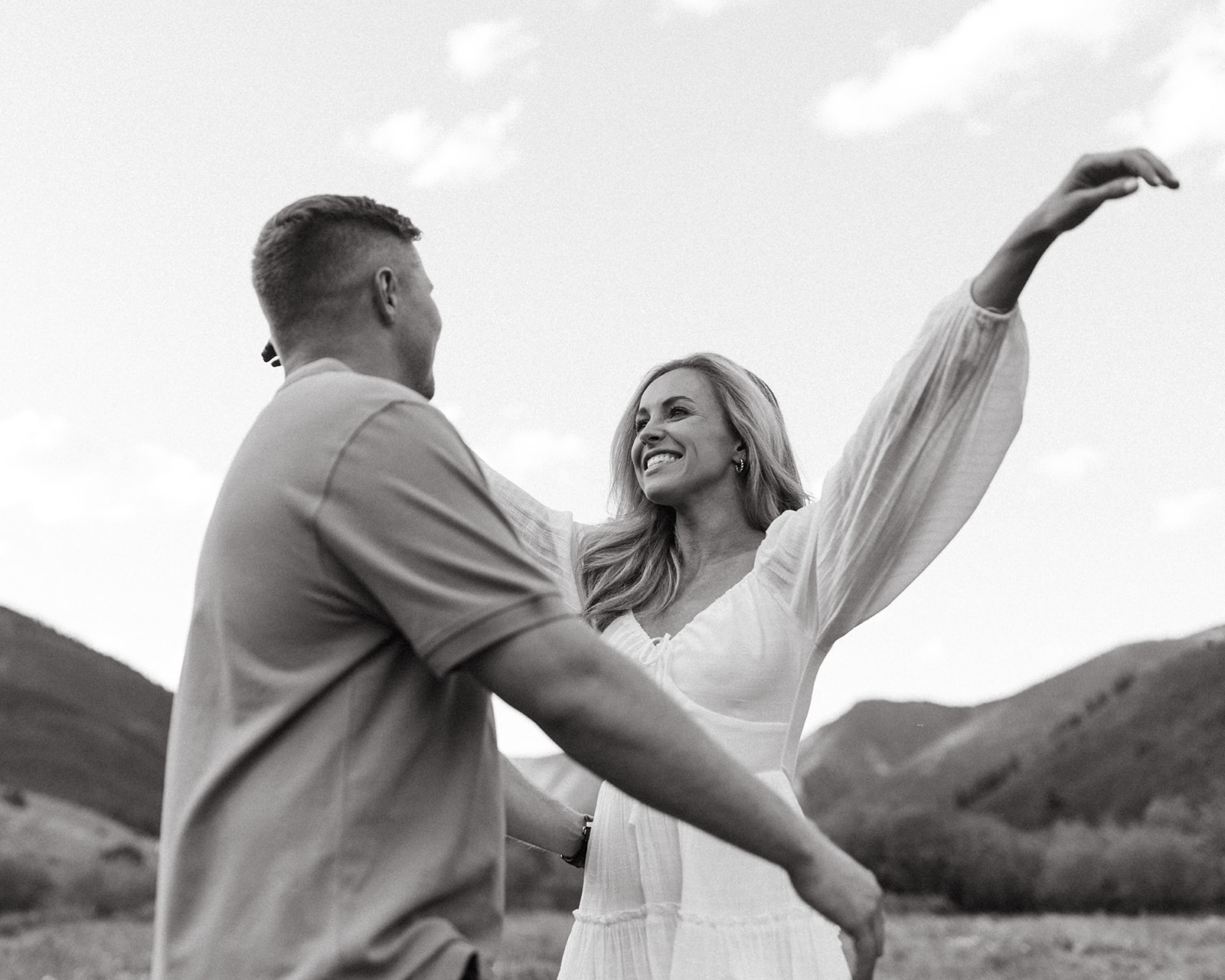 An engaged couple goes in for a hug during their mountain engagement session in the Colorado Rockies near Aspen.