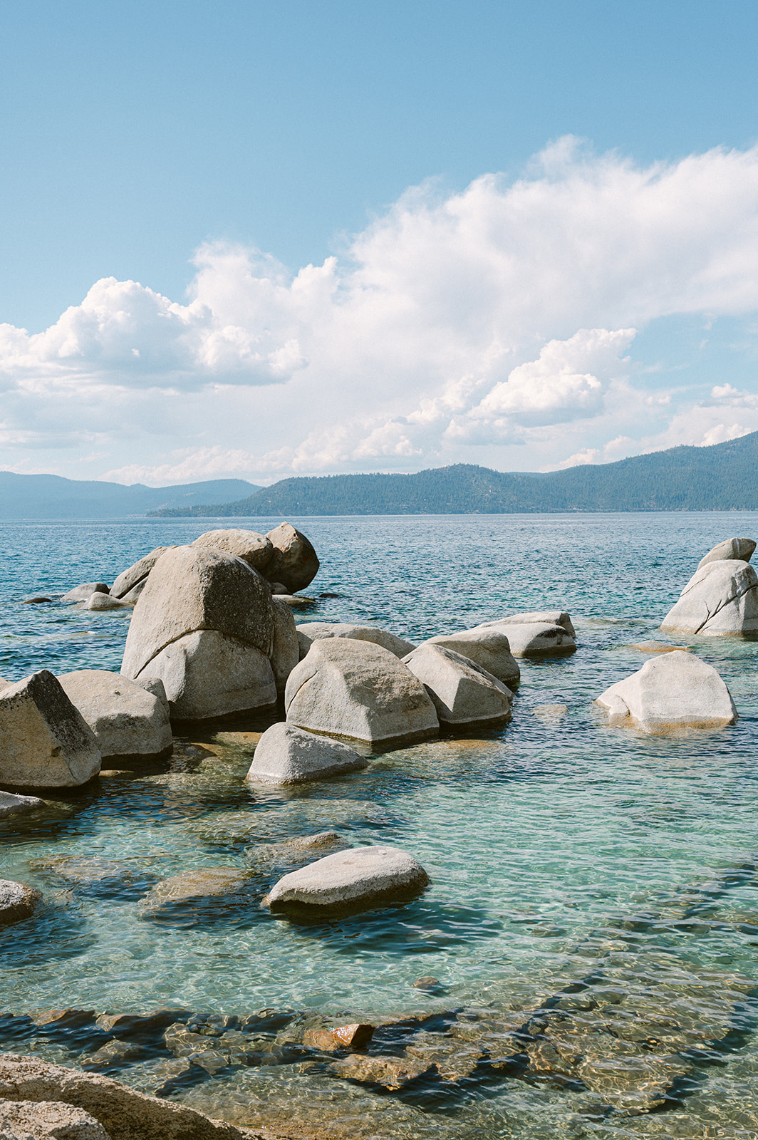 large white boulders in lake tahoe with crystal blue teal water below