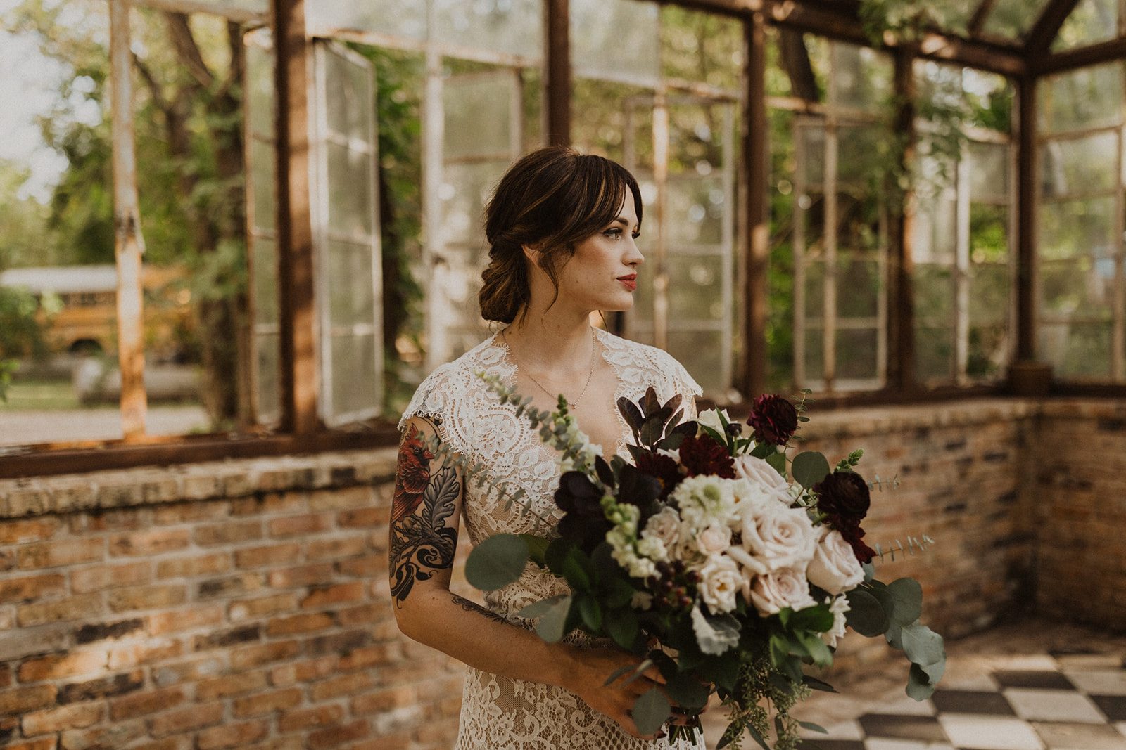 bride holds white rose wedding bouquet at greenhouse wedding